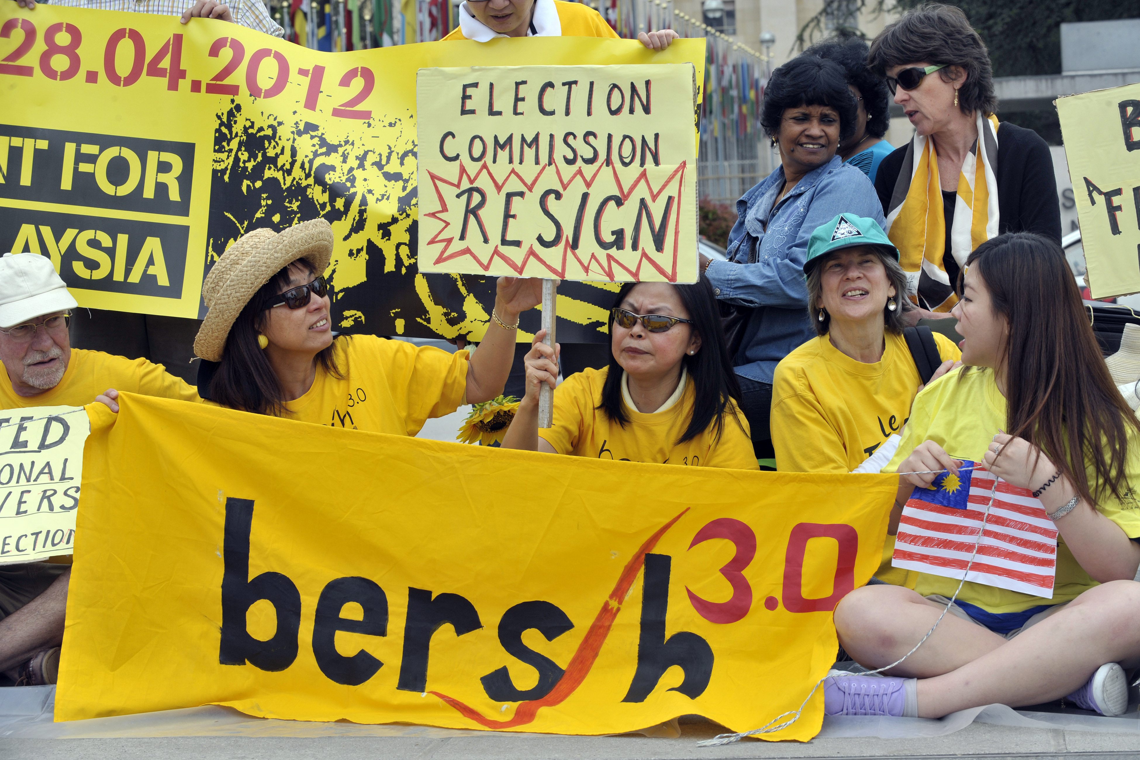 Demonstrators of the Malayan movement Bersih for democracy hold banners to ask for free and fair elections in Malaysia in front of the European headquarters of the United Nations in Geneva on April 28, 2012.