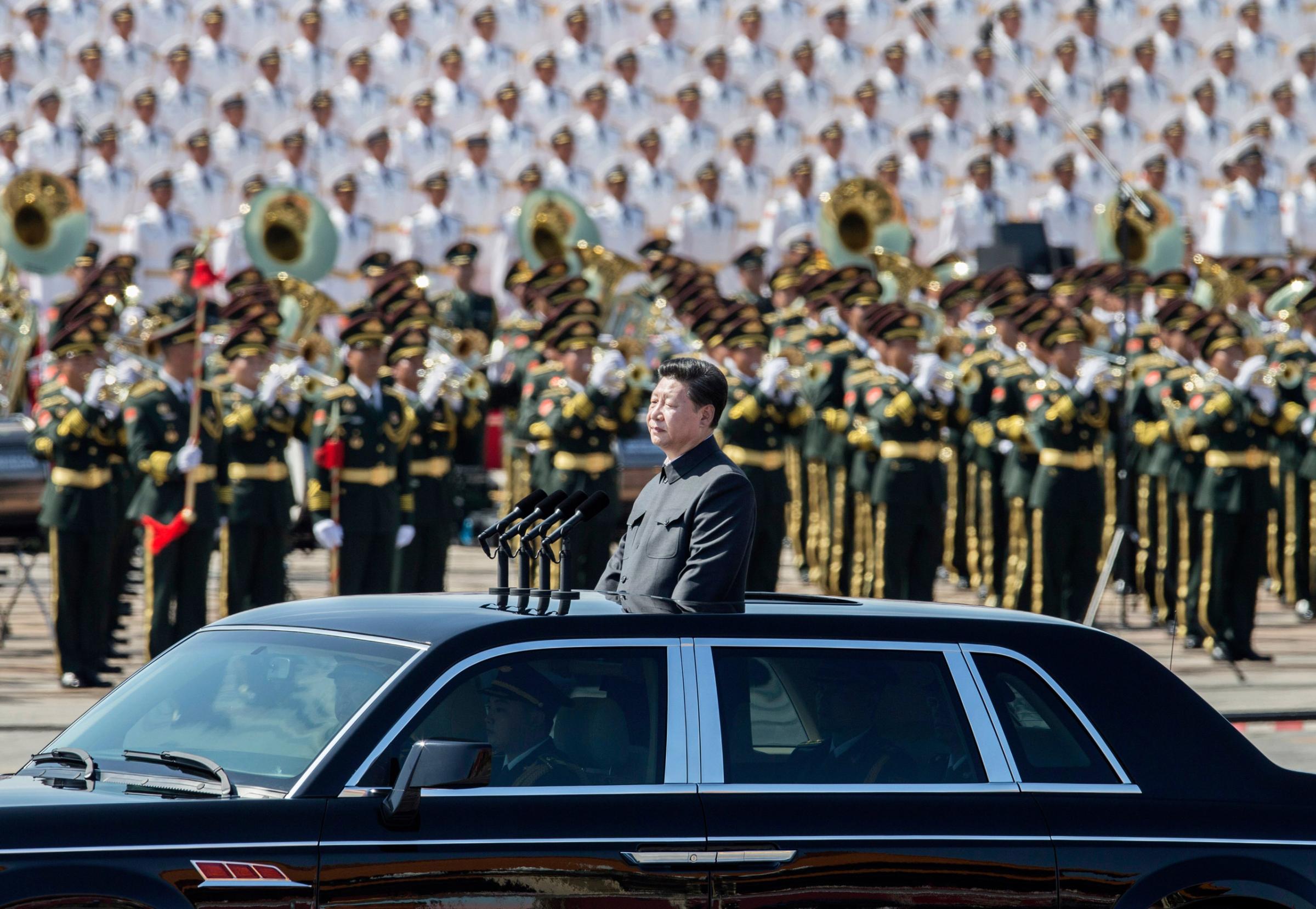 BEIJING, CHINA - SEPTEMBER 03: Chinese president and leader of the Communist Party Xi Jinping rides in an open top car in front of Tiananmen Square and the Forbidden City during a military parade on September 3, 2015 in Beijing, China. China is marking the 70th anniversary of the end of World War II and its role in defeating Japan with a new national holiday and a military parade in Beijing. (Photo by Kevin Frayer/Getty Images)