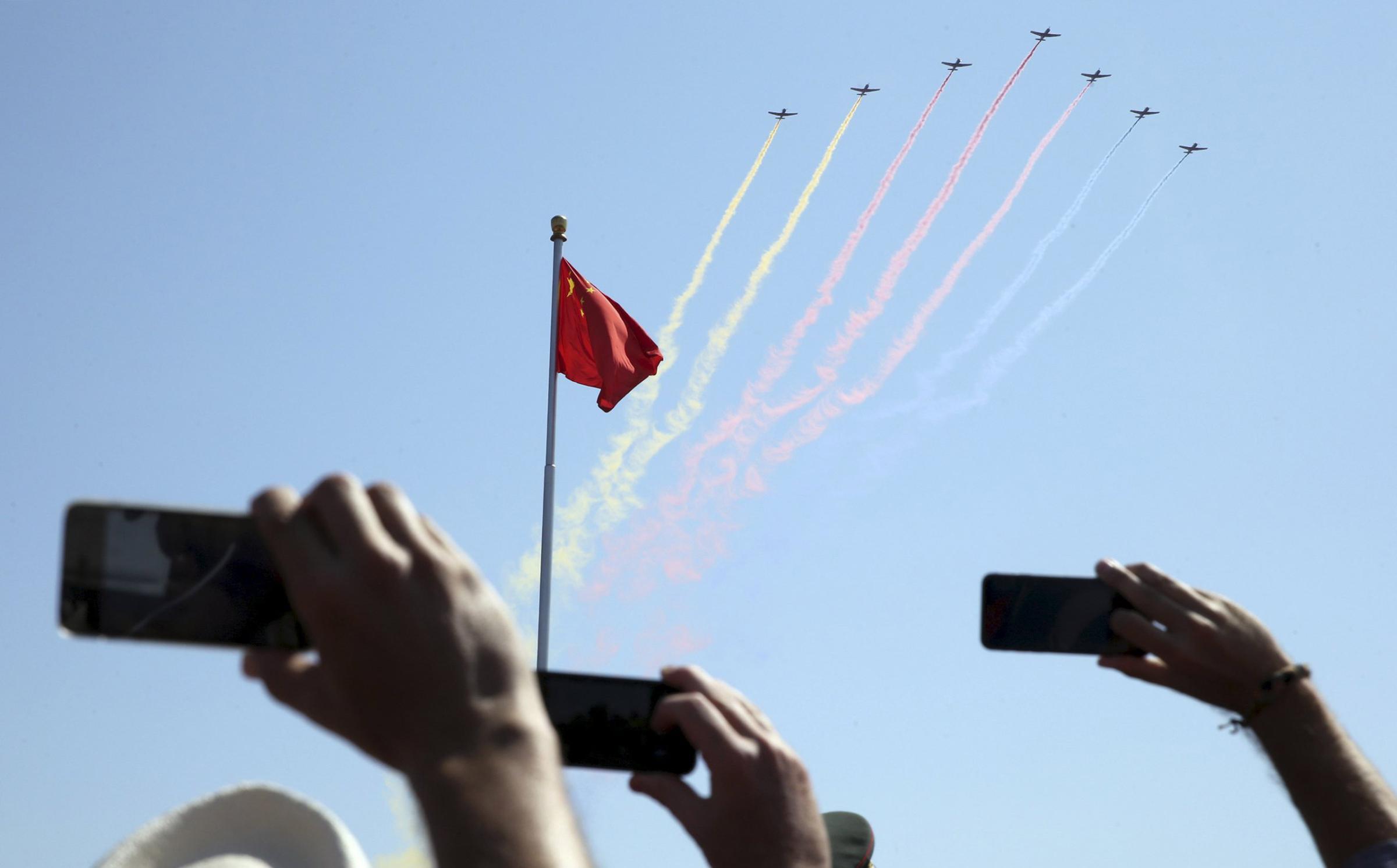 People record trainer jets flying over Tiananmen Square during a military parade to mark the 70th anniversary of the end of World War Two, in Beijing, China, September 3, 2015. REUTERS/China Daily CHINA OUT. NO COMMERCIAL OR EDITORIAL SALES IN CHINA TPX IMAGES OF THE DAY