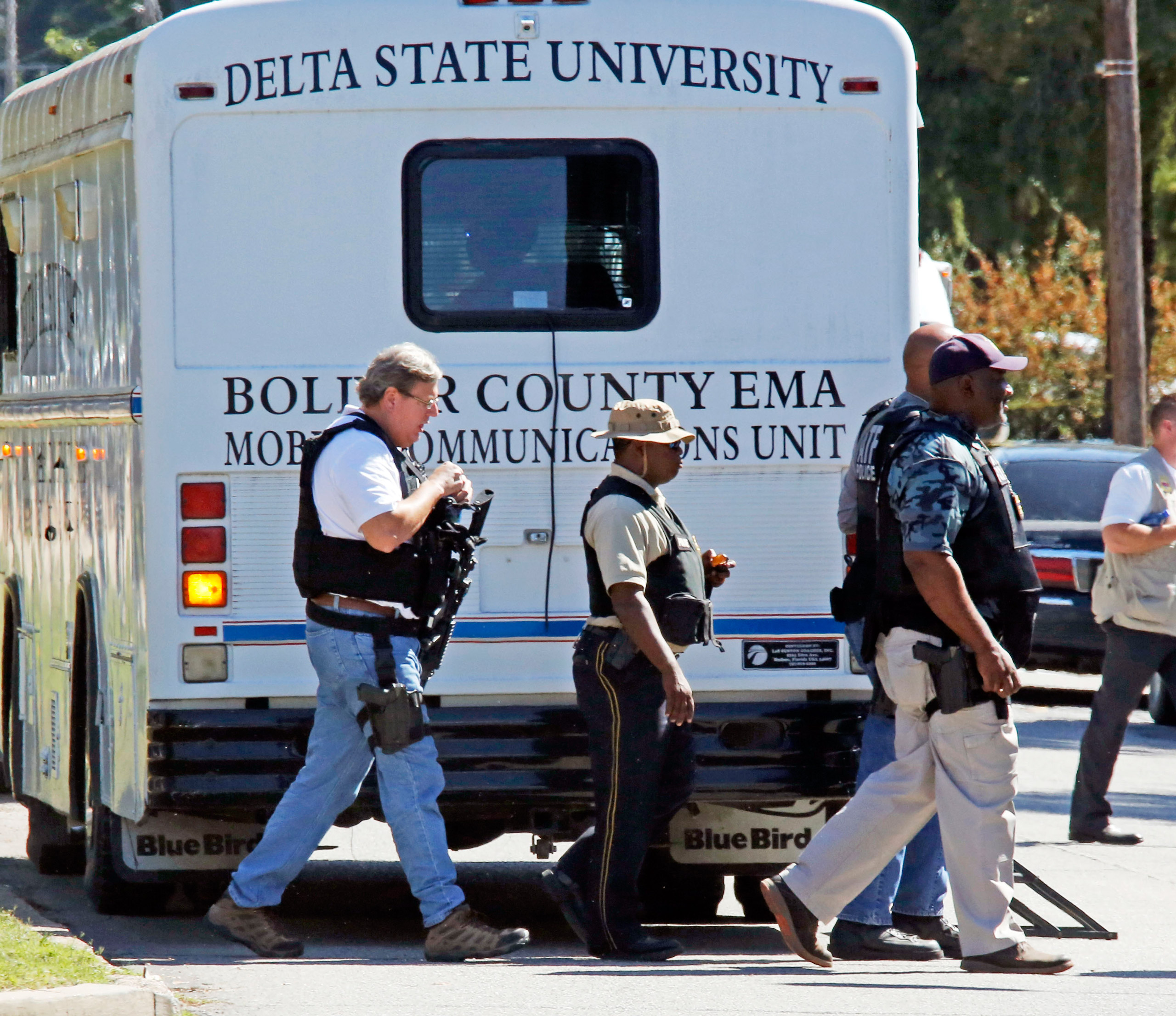 Law enforcement walk across the Delta State University campus to search for an active shooter in connection with a the shooting of history professor Ethan Schmidt in his office at Delta State University in Cleveland, Miss., Monday, Sept. 14, 2015. Law enforcement are looking for a another school employee in connection with the killing. (AP Photo/Rogelio V. Solis)