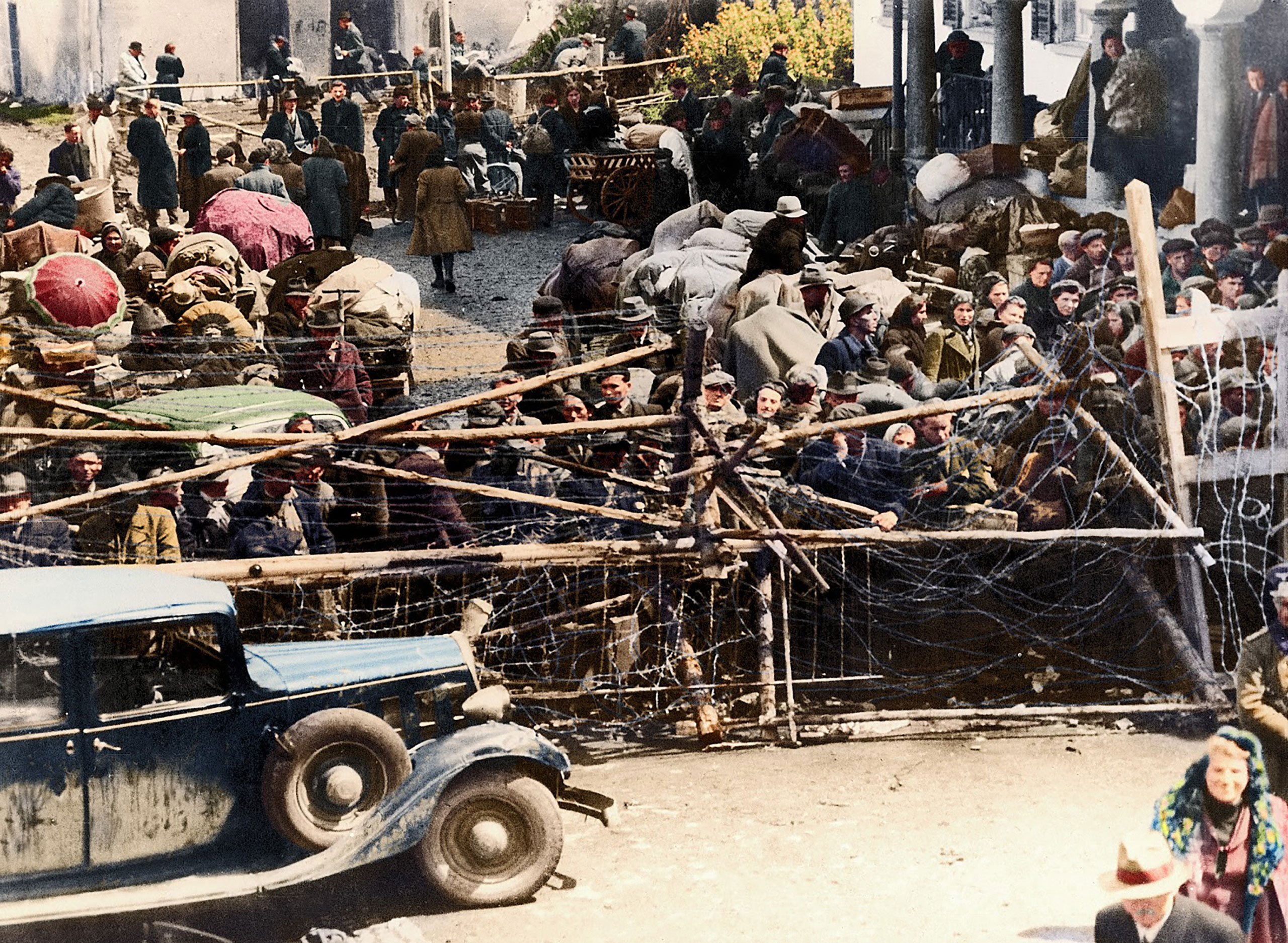 A crowd of refugees stood behind barbed wire on May 18, 1945, while waiting to cross the border into the neutral state of Lichstenstein. A thorough check by the customs office had to be performed for each of these displaced persons.