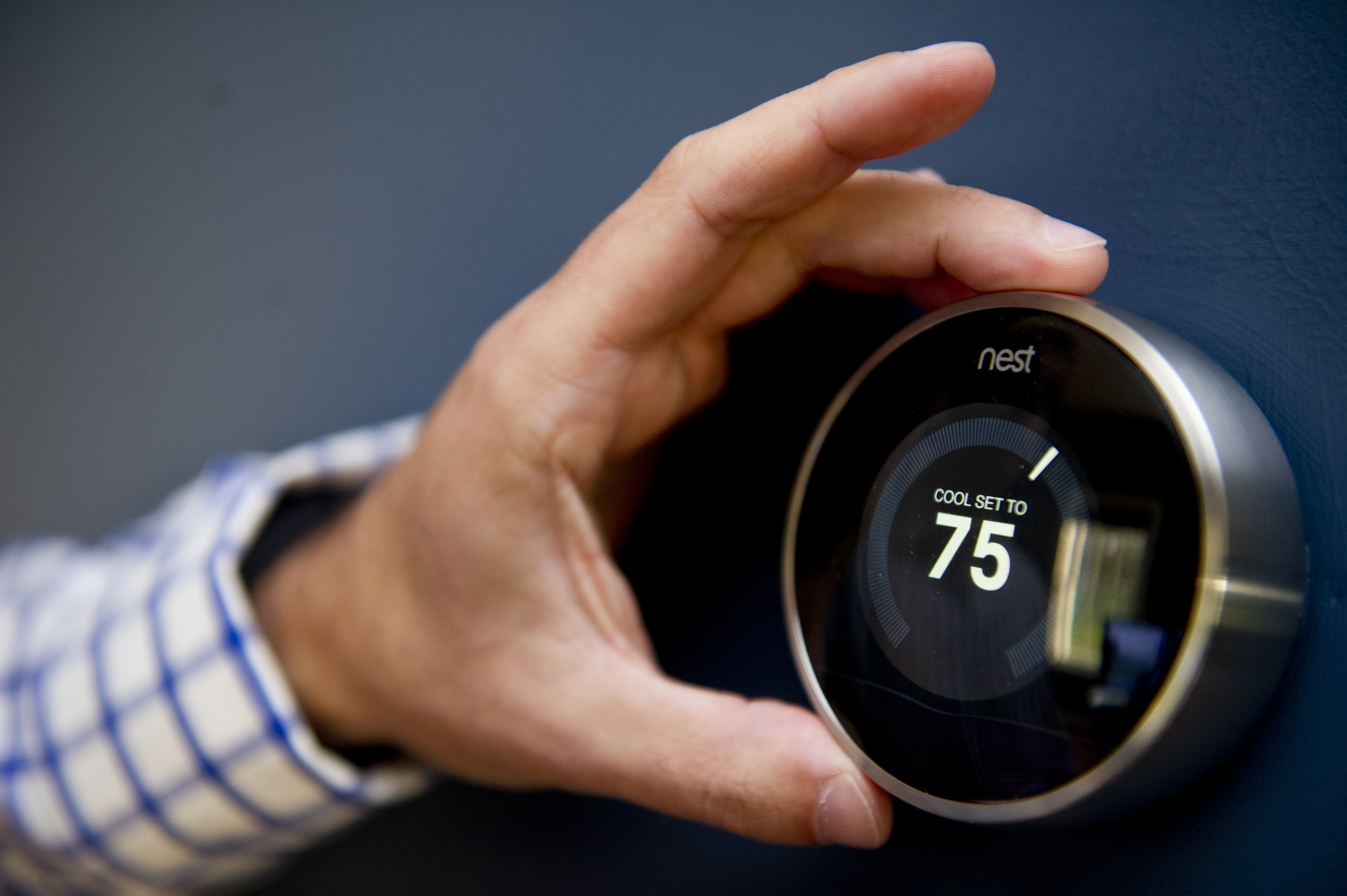 Nick DeLena adjusts his thermostat from Nest Labs in his home on August 12, 2013 in West Newbury, Massachusetts. (Christian Science Monitor&mdash;Christian Science Monitor/Getty)