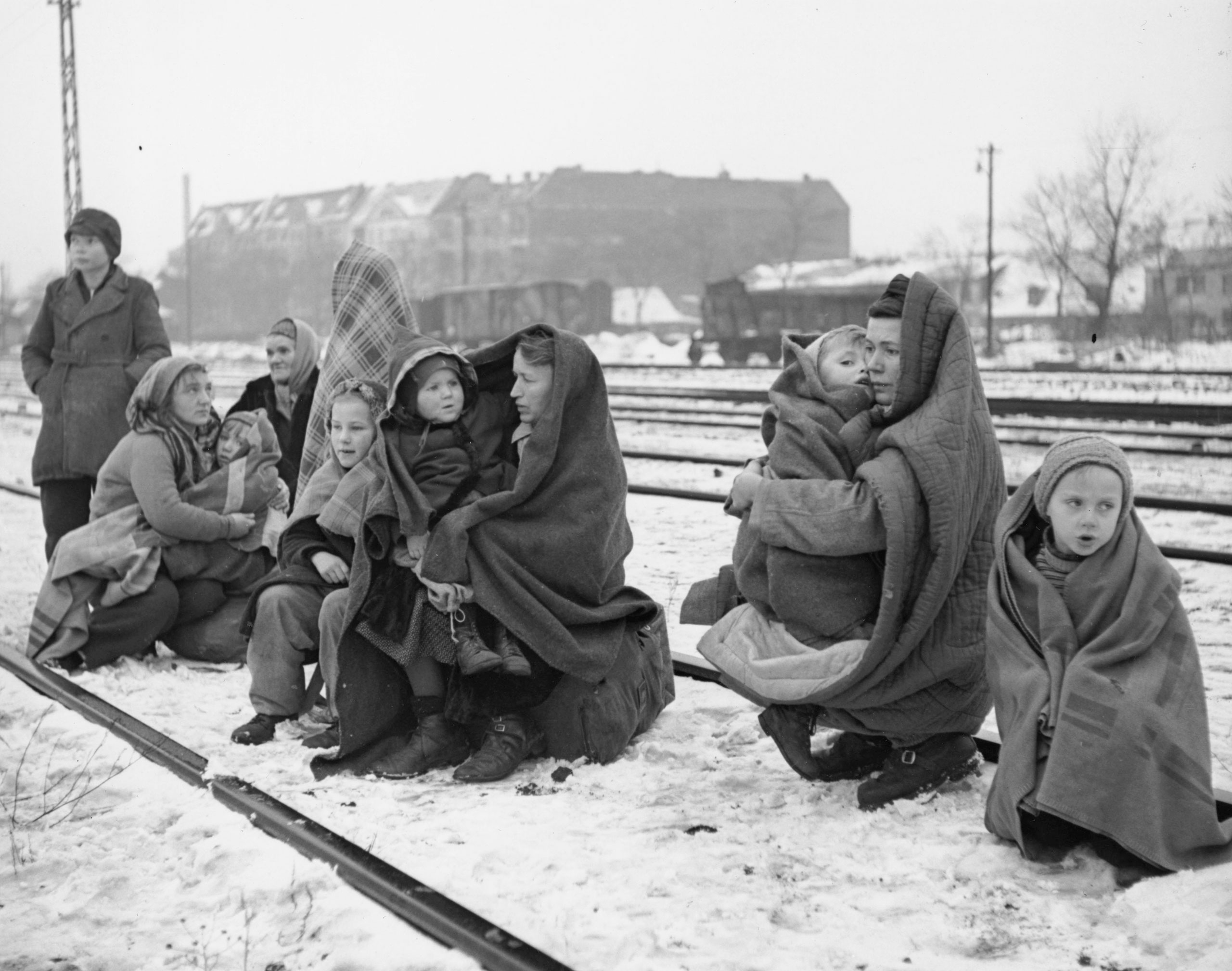 The only survivors of 150 Polish people who walked from Lodz, Poland to Berlin Huddle in blankets, on December 14, 1945. They are waiting by a railway track hoping to be picked up by a British army train and given help.