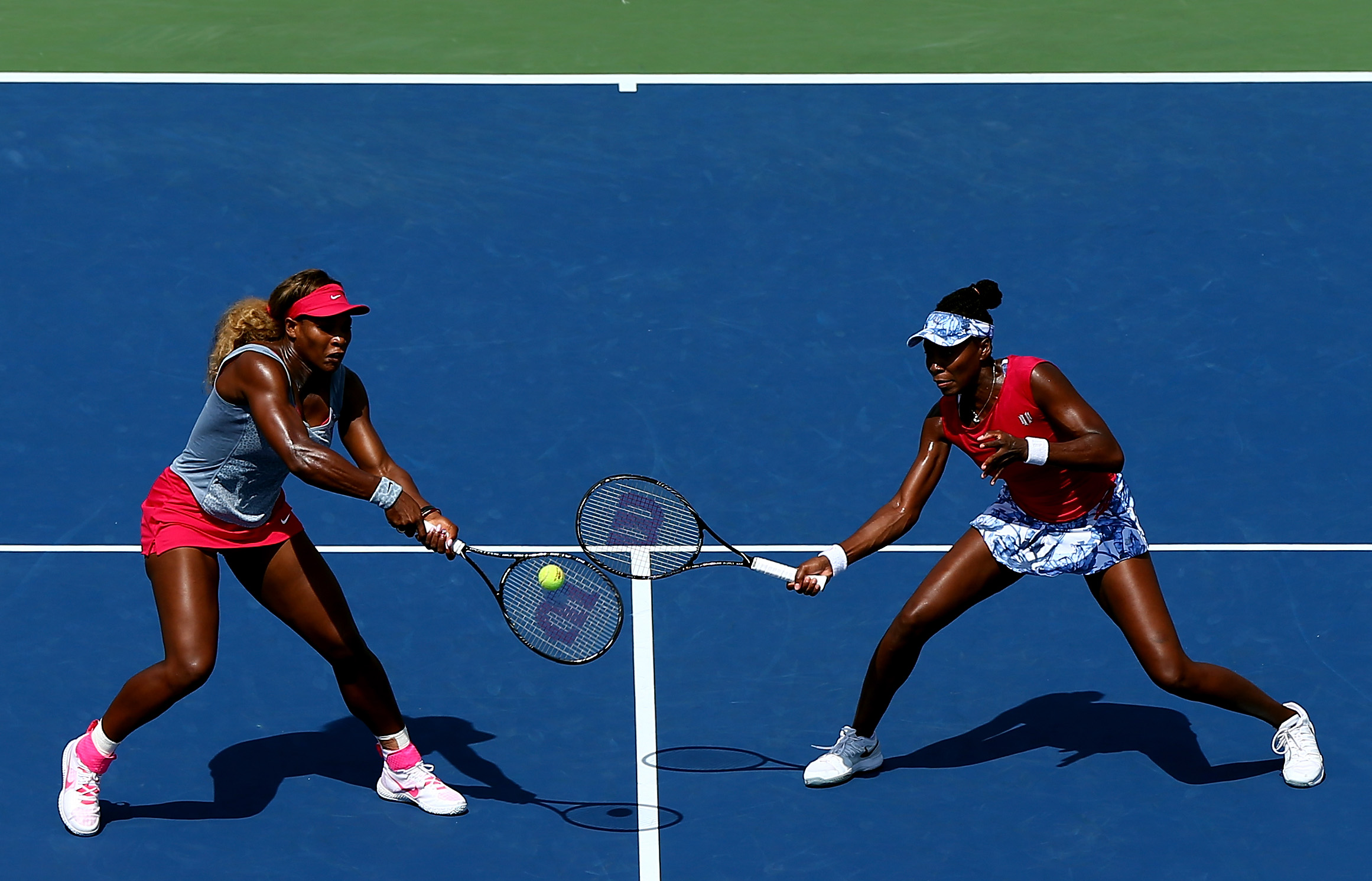 Venus Williams (R) and Serena Williams (L) of the United States return a shot against Ekaterina Makarova and Elena Vesnina of Russia during their women's doubles quarterfinal match on Day Nine of the 2014 US Open at the USTA Billie Jean King National Tennis Center on September 2, 2014 in the Flushing neighborhood of the Queens borough of New York City. (Elsa&mdash;Getty Images)