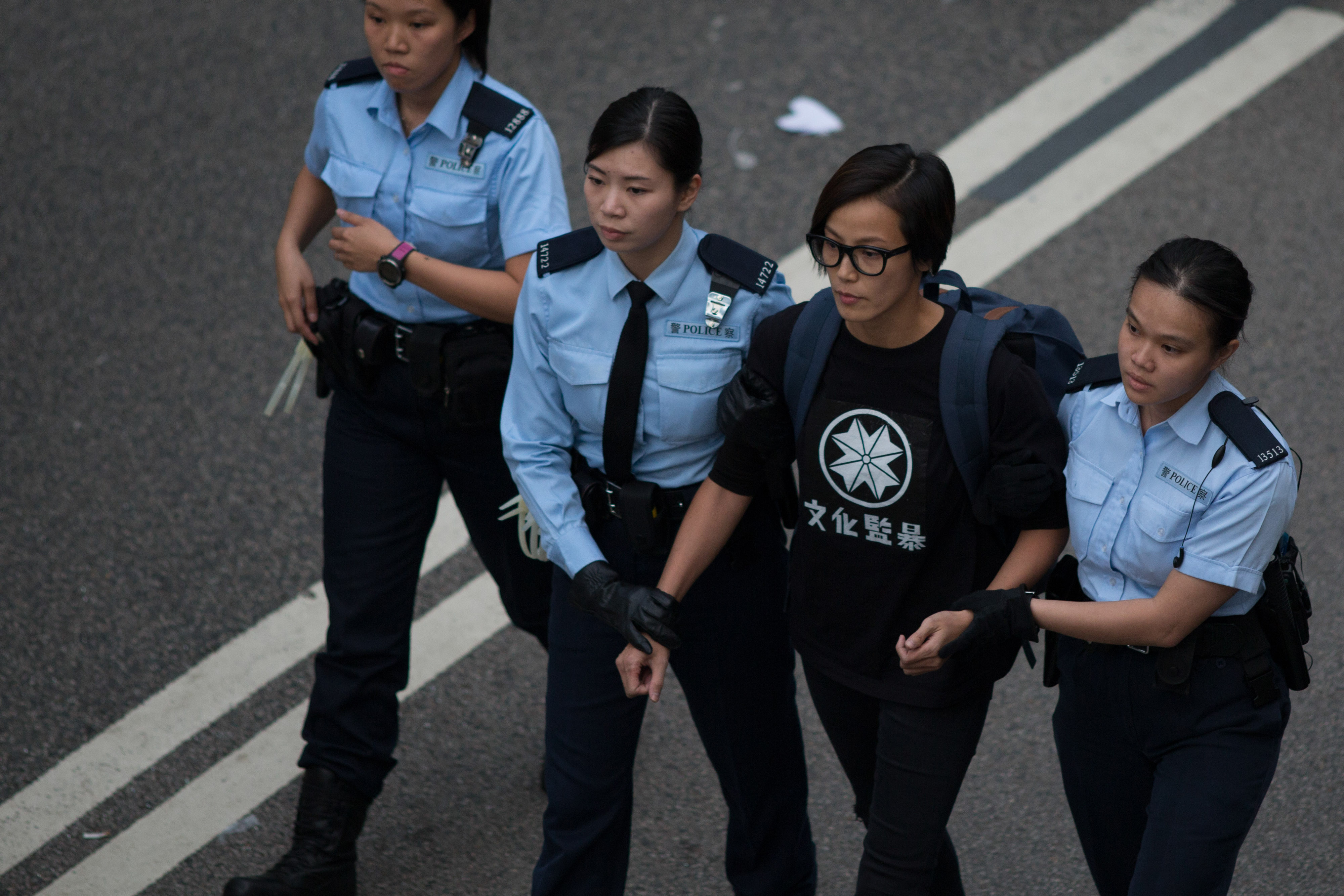 Popular singer Denise Ho is escorted by police officers near the Central Government Offices in the Admiralty district of Hong Kong on Dec. 11, 2014 (Bloomberg/Getty Images)