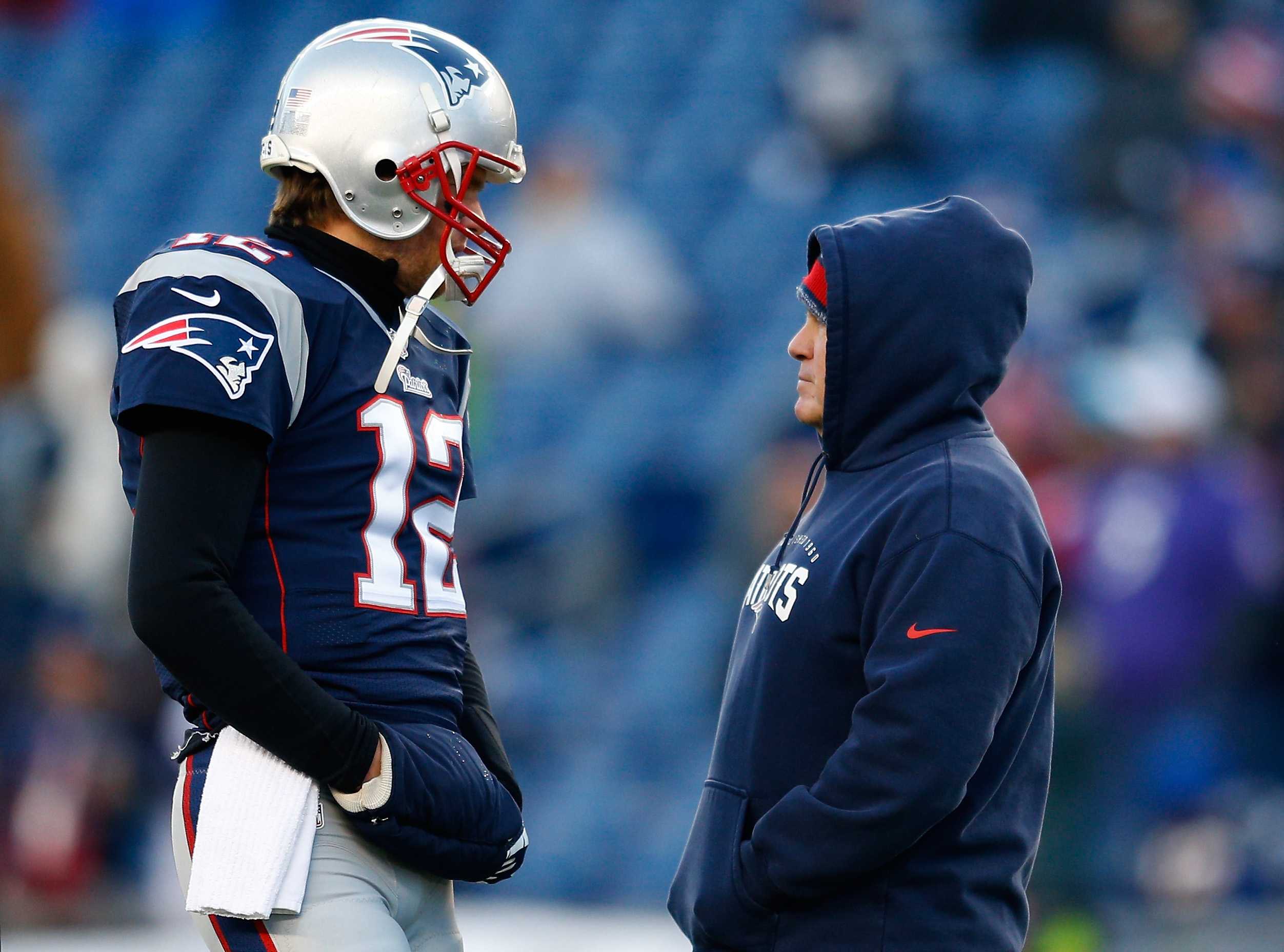 Tom Brady #12 and head coach Bill Belichick of the New England Patriots talk before the 2014 AFC Divisional Playoffs game against the Baltimore Ravens at Gillette Stadium on January 10, 2015 in Foxboro, Massachusetts (Jim Rogash—Getty Images)