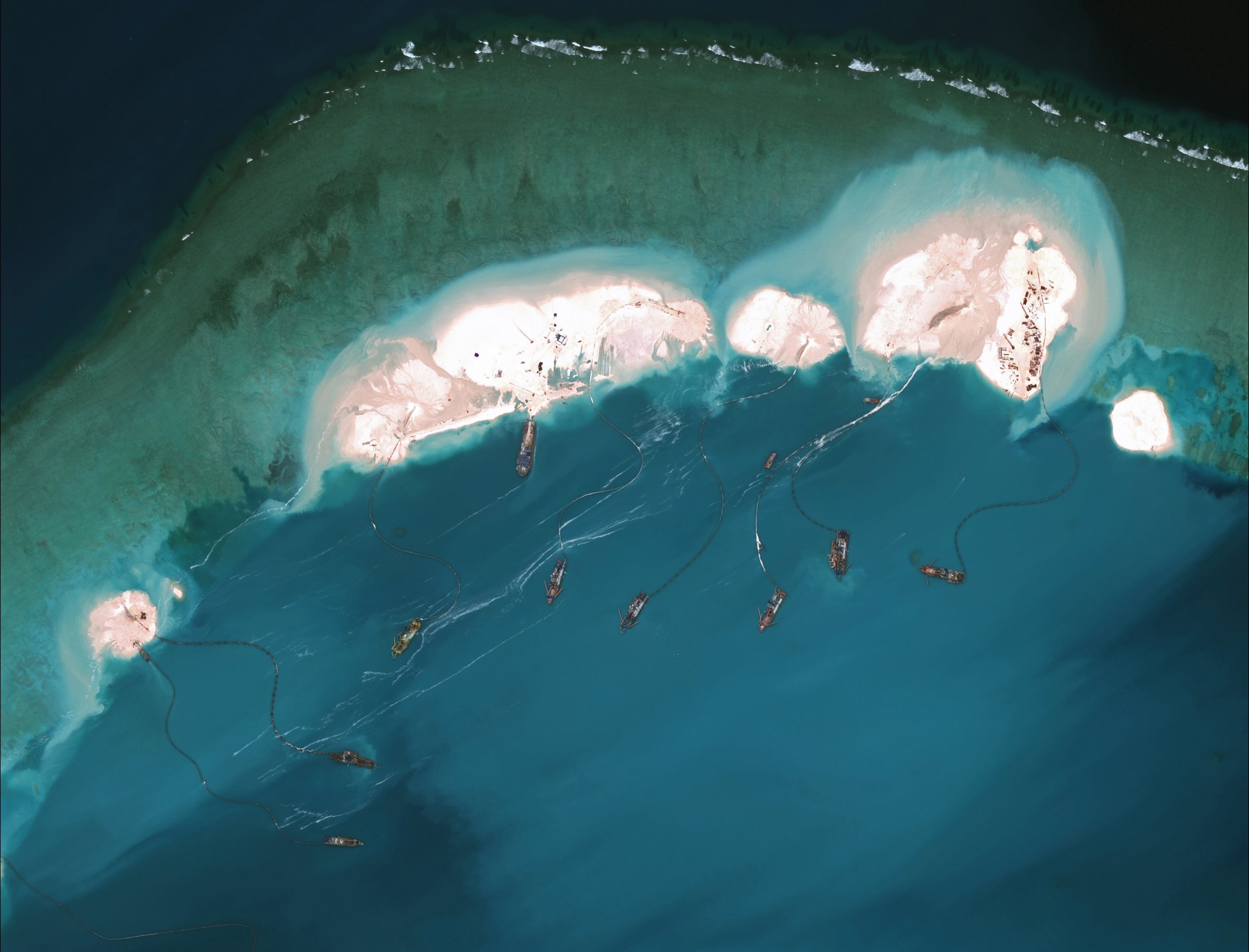 DigitalGlobe imagery from 16 March 2015 shows significant construction and dredging underway at Mischief Reef. New structures, fortified seawalls, and construction equipment are present at multiple sites.