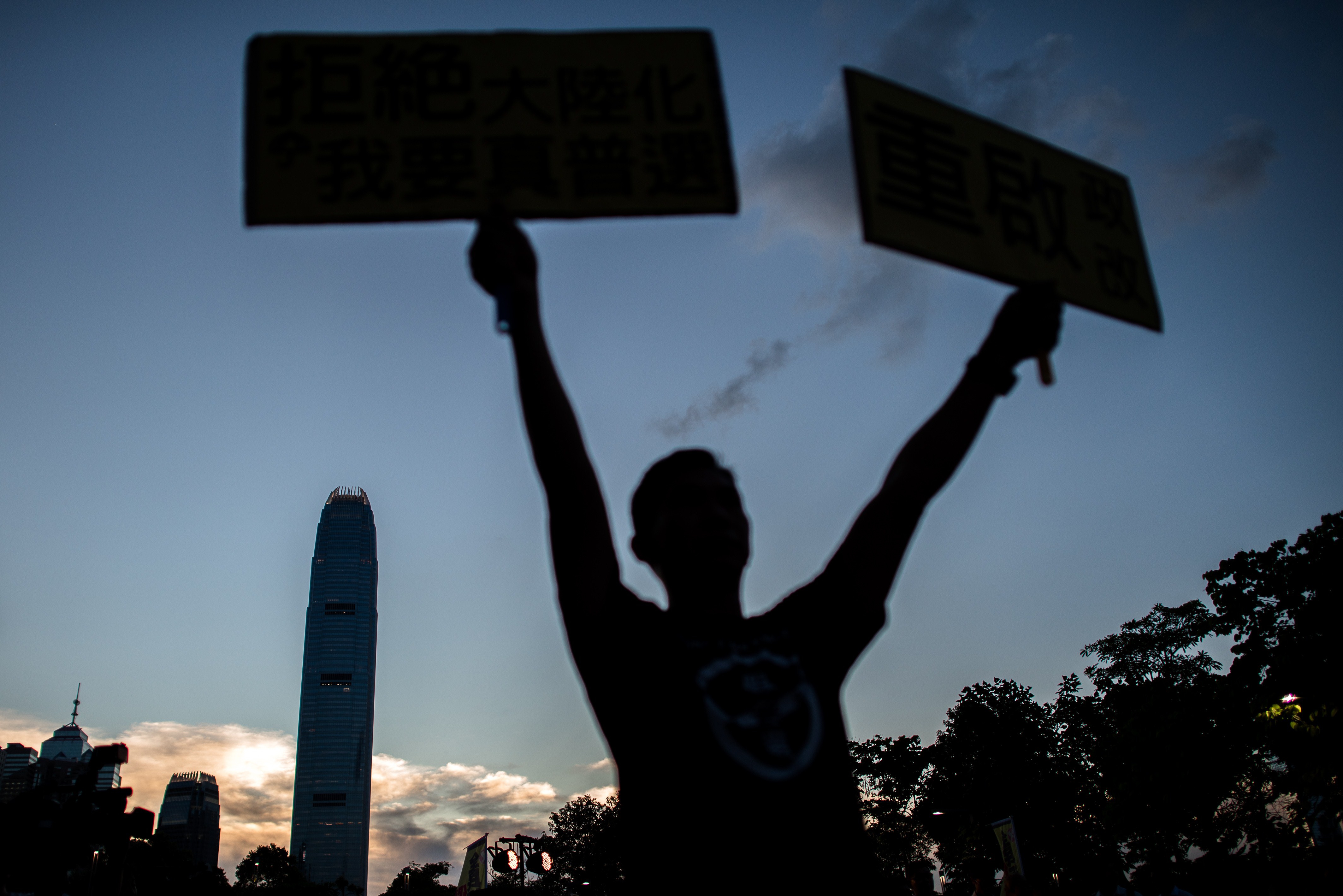 A pro-democracy campaigner holds placard during sunset outside the city's legislature in Hong Kong on June 15, 2015, ahead of a key vote on the government's controversial political reform package. (Philippe Lopez—AFP/Getty Images)