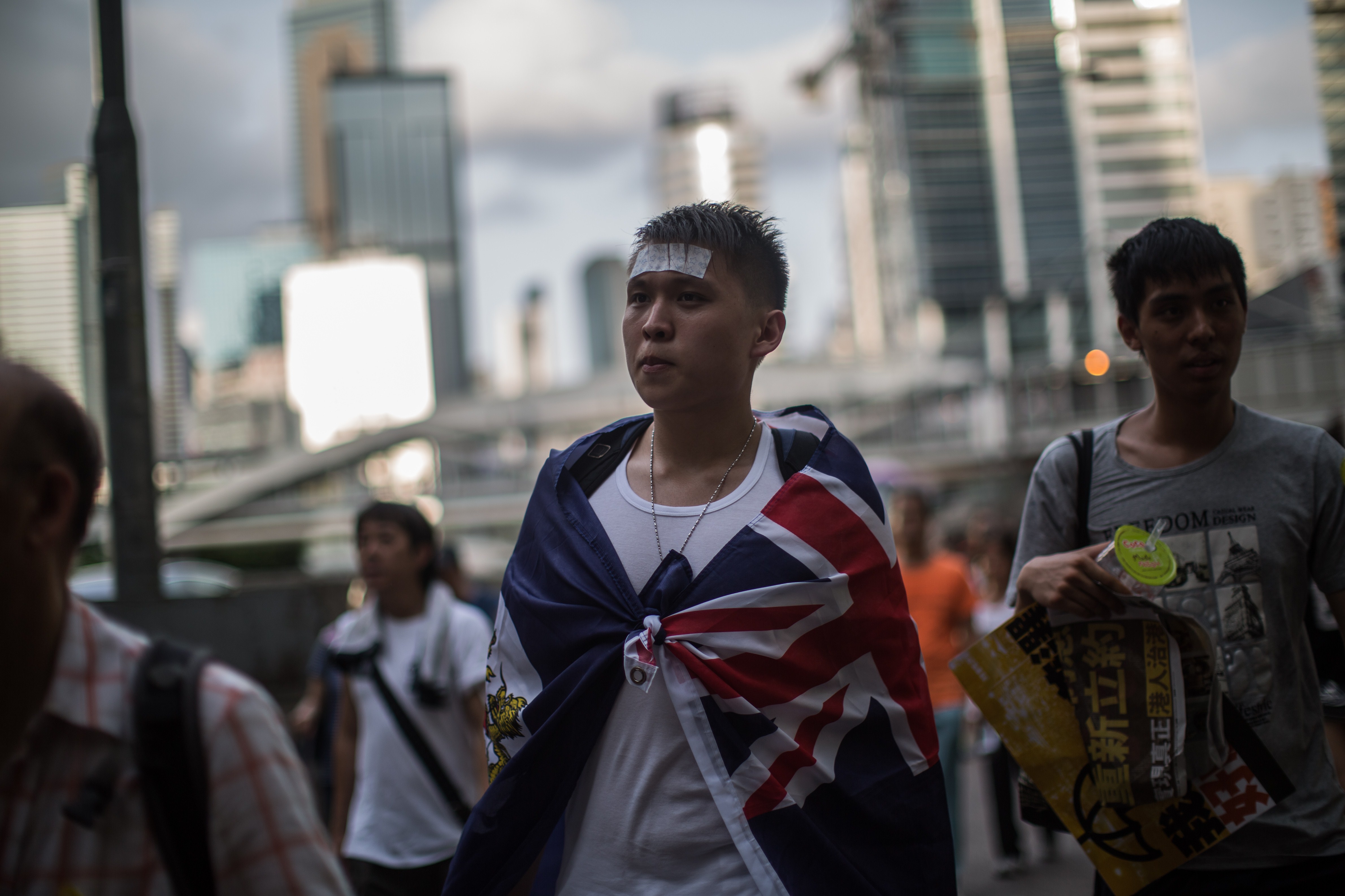 A protester wears the colonial Hong Kong flag around his shoulders as he attends a pro-democracy rally in Hong Kong on July 1, 2015 (Anthony Wallace—AFP/Getty Images)