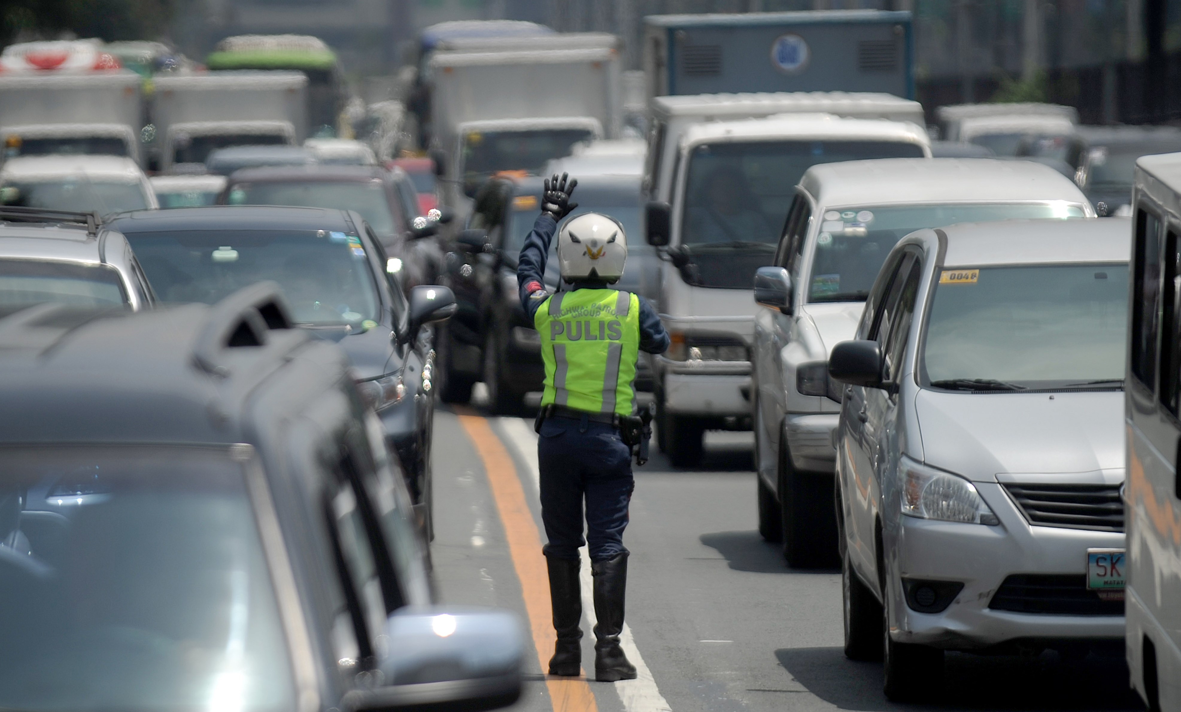 A police officer controls traffic at Epifanio de los Santos Avenue, popularly known as EDSA, in Manila on Sept. 8, 2015 (Jay Directo—AFP/Getty Images)