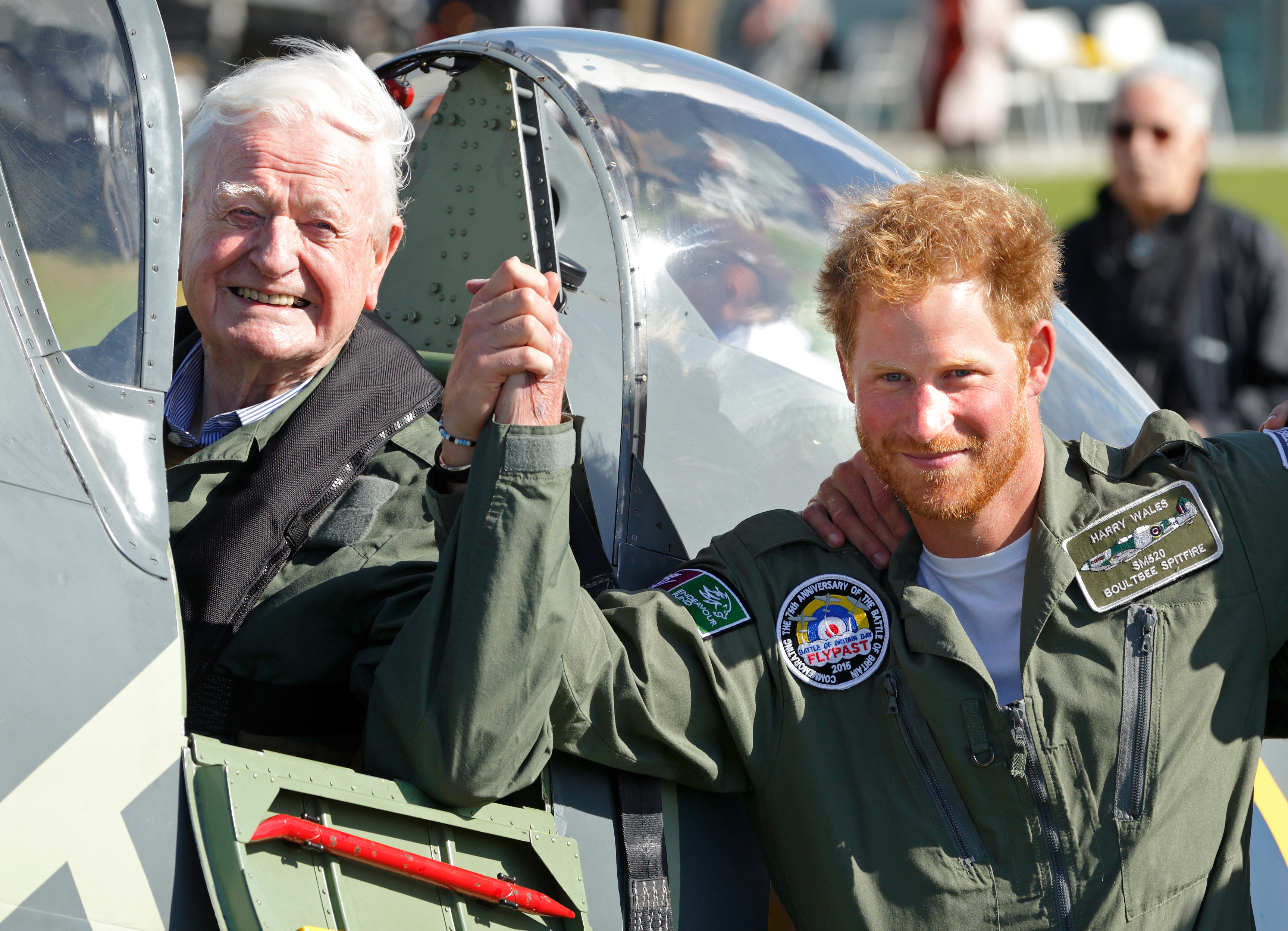 Prince Harry holds hands with 95-year-old Battle of Britain veteran Tom Neil after he landed back at Goodwood Aerodrome in his Spitfire aircraft following a Battle of Britain Flypast on Sept. 15, 2015, in Chichester, England (Max Mumby—Getty Images)