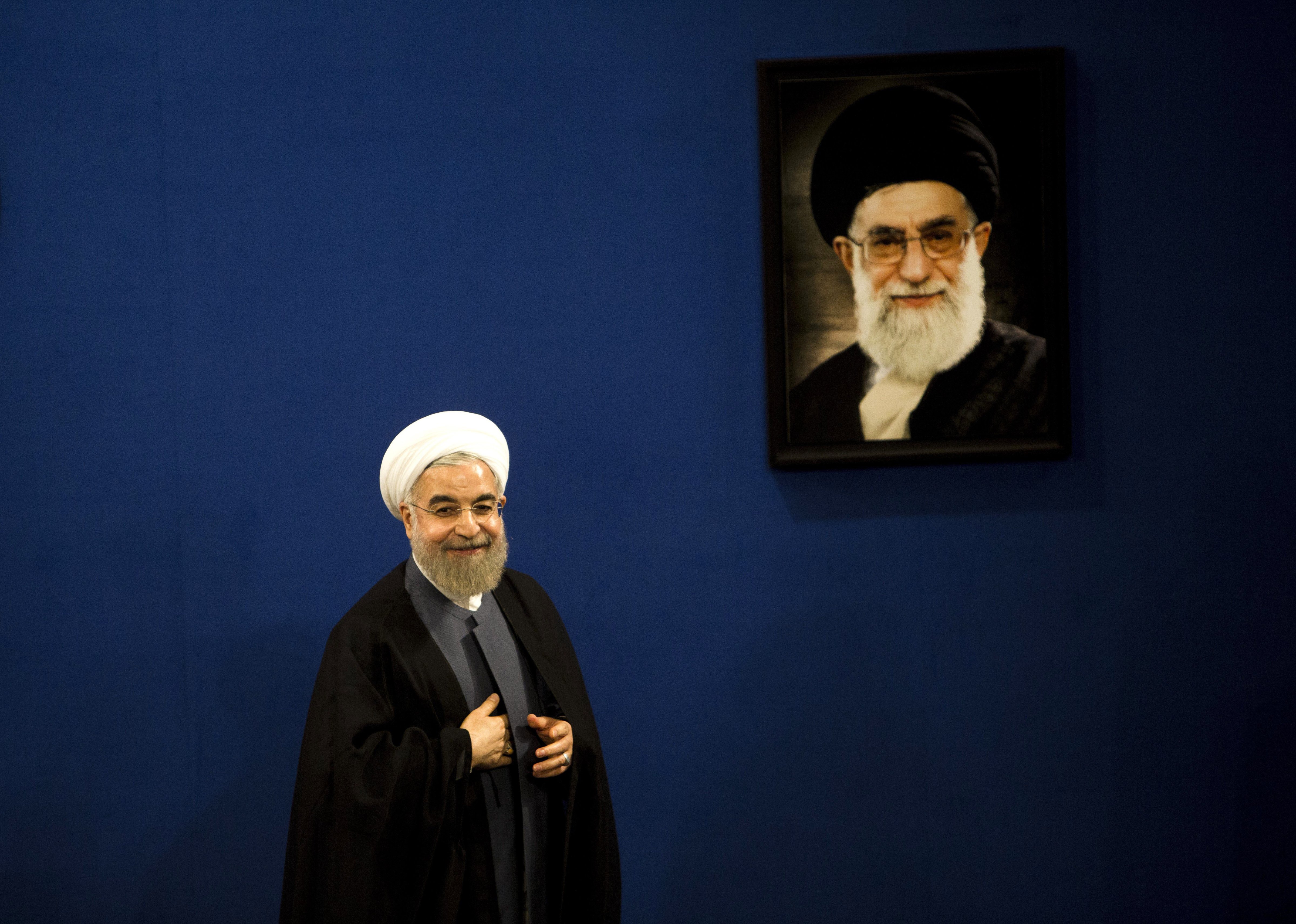 Iranian President Hassan Rouhani stands next to a portrait of supreme leader Ayatollah Ali Khamenei in Tehran on June 13, 2015.