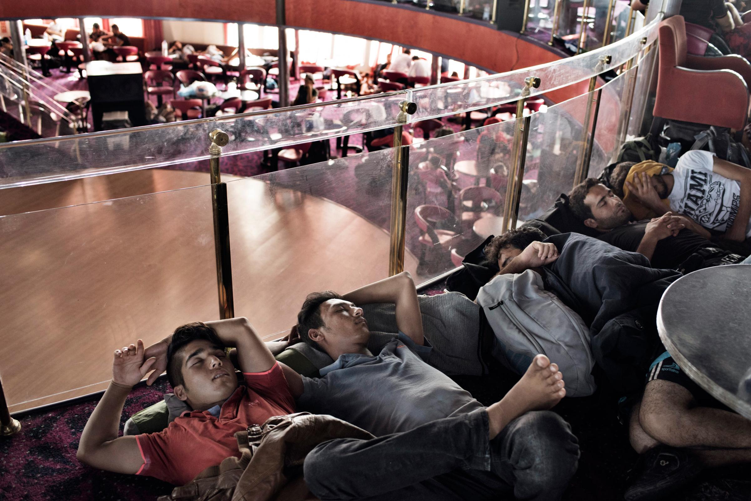 KOY201509060155, 157, 165Migrants rest and recharge their phones aboard a cruise ship that the Greek government chartered to transport them to Athens from the Greek island of Lesbos. The regular ferry service traveling this route was unable to cope with the unprecedented influx of migrants going through Greece to Western Europe from various conflict zones across the Muslim world.Photograph by Yuri Kozyrev/ NOOR for TIME