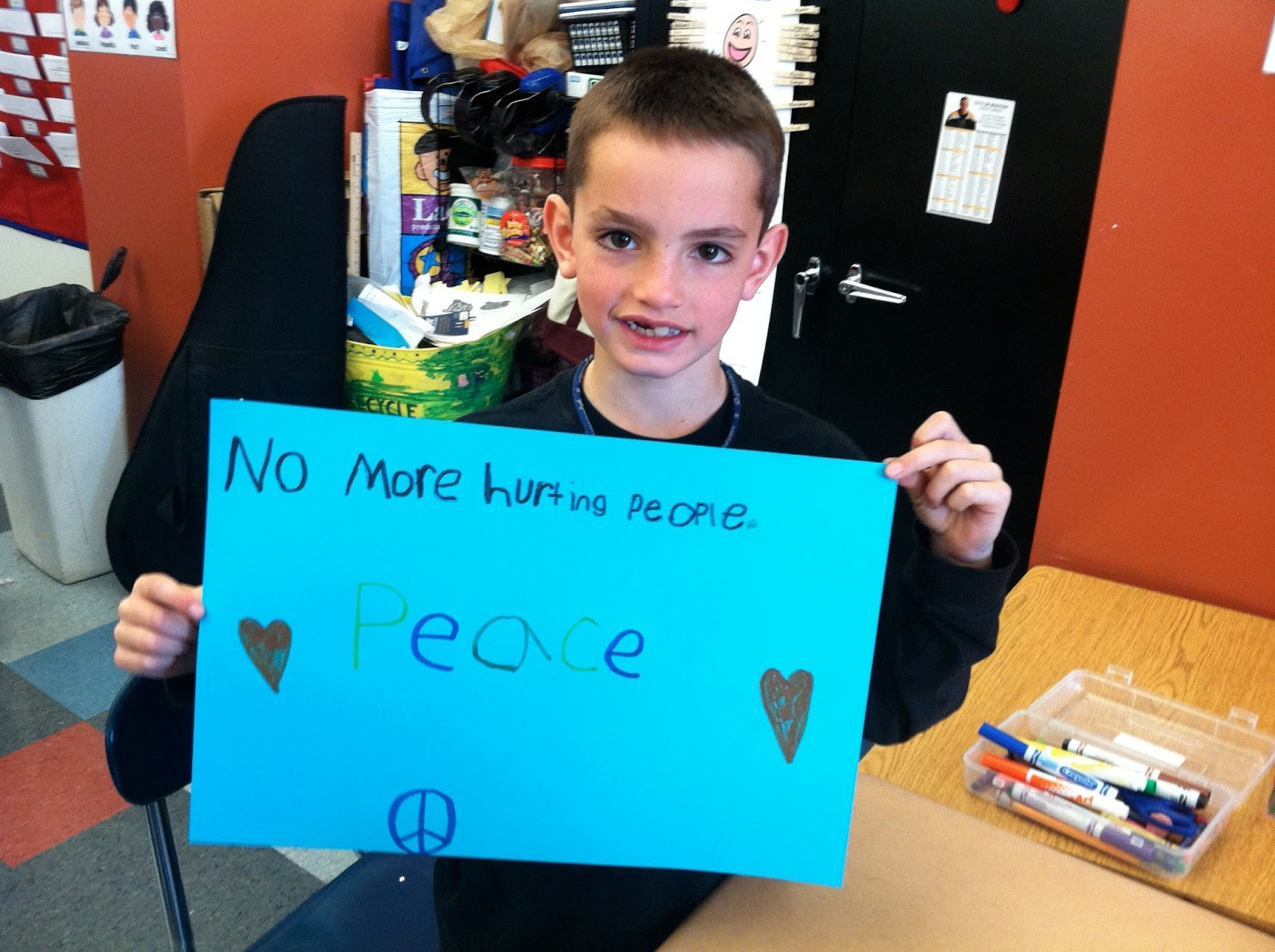 Martin Richard holding a poster he created in 2012 that reads ‘No More Hurting People – Peace.’ The image touched countless hearts across the nation in the days after the bombings at the 2013 Boston Marathon. (Martin Richard Foundation)