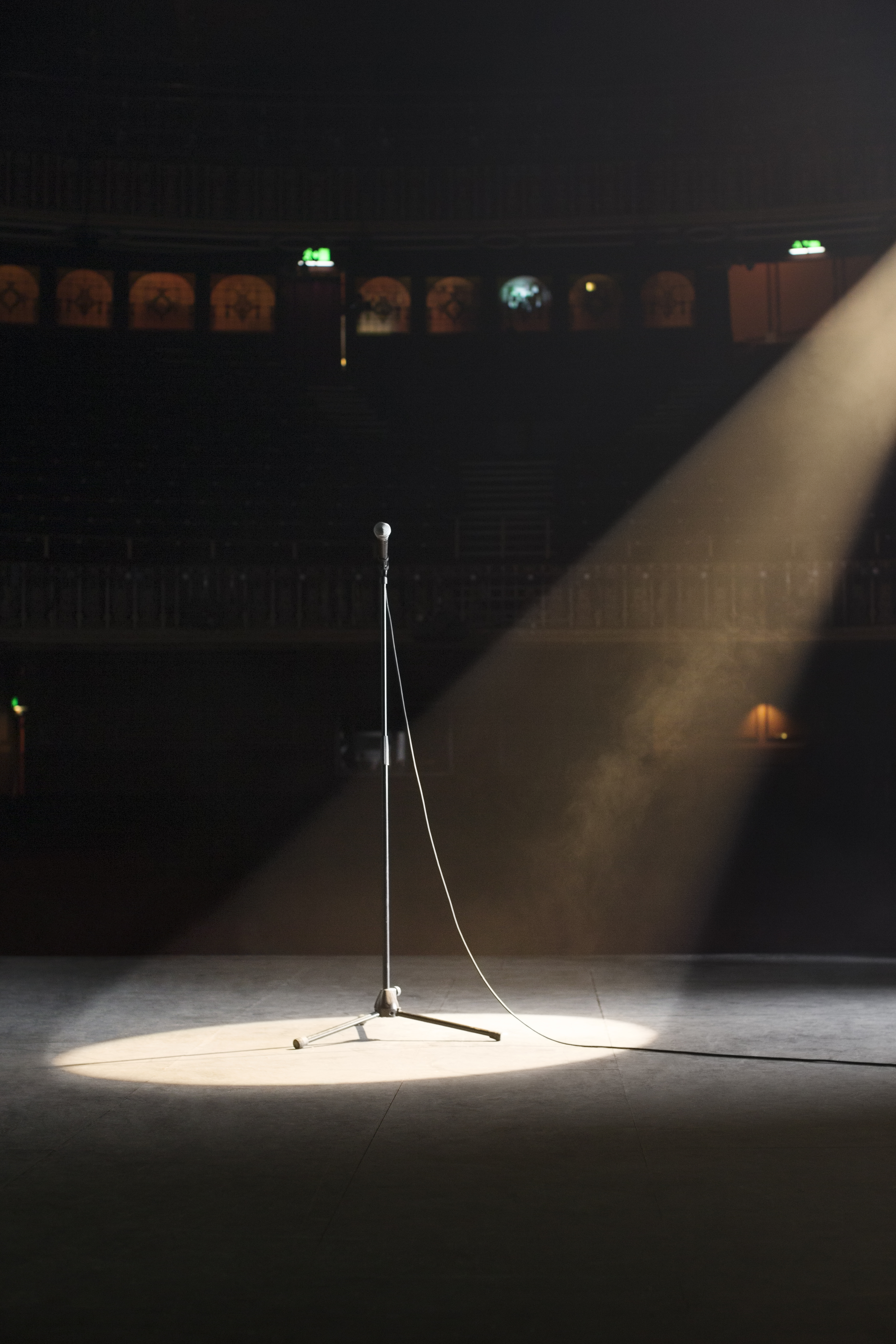 Microphone in spotlight on empty theater stage