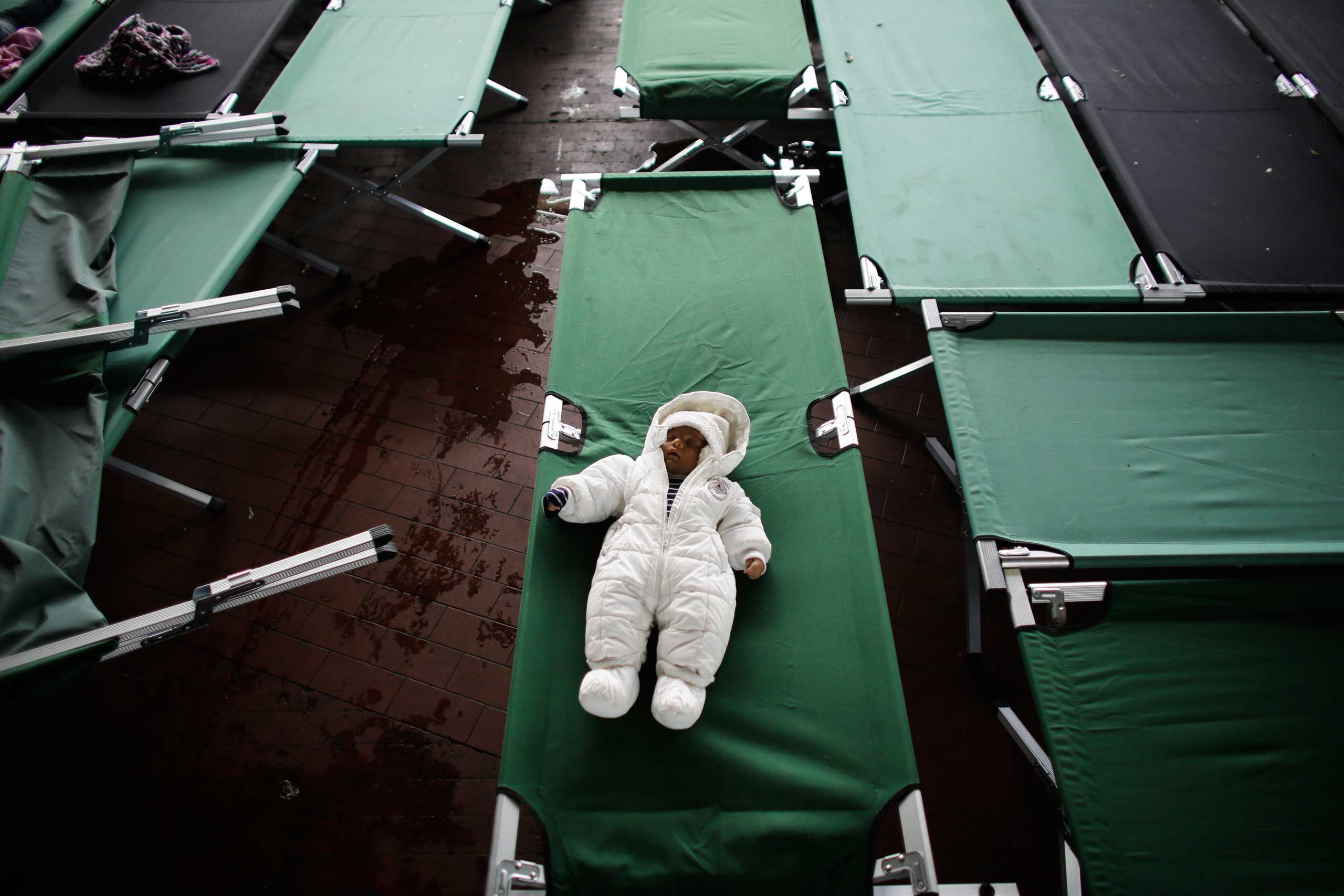 Three month old baby Parwan from Afghanistan sleeps on a bed at the temporary registration center of the southern German border town Passau, on Sept. 15, 2015. (Markus Schreiber—AP)