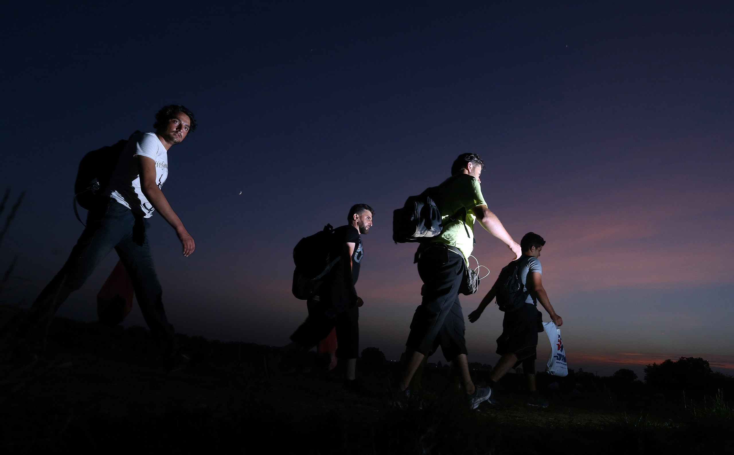 Migrants walk towards the eastern-Croatia town of Tovarnik, close to the border between Croatia and Serbia, on September 18, 2015. Migrants have begun carving a new route into the Schengen area, traveling via Croatia, after neighboring Hungary, overwhelmed by the refugee traffic, fenced off its own border with Serbia. For the moment, Croatia copes well with the influx of refugees, being still able to keep evidence of the people arriving and transporting them by train to refugee transit centers closer to nation's capital, Zagreb. AFP PHOTO / STRSTR/AFP/Getty Images