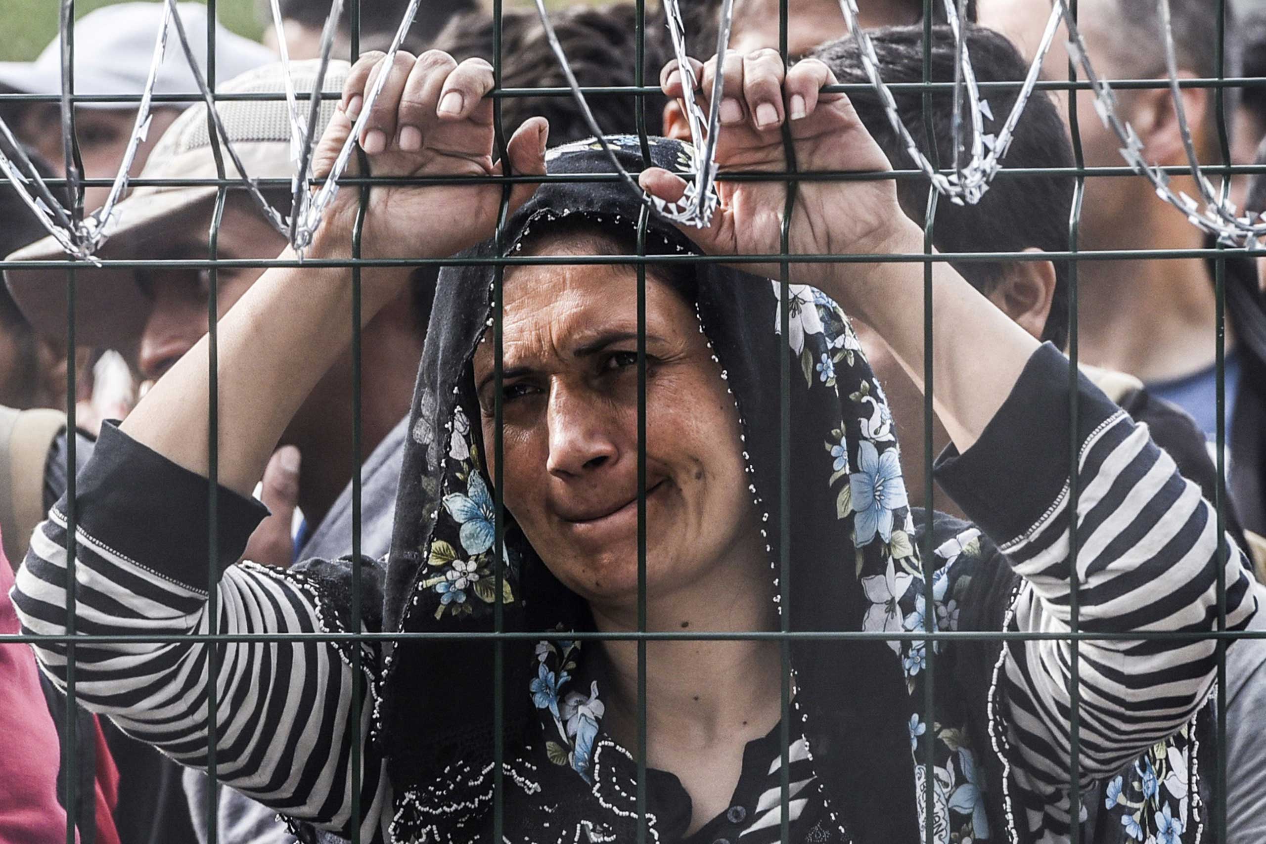 A refugee stands behind a fence at the Hungarian border with Serbia near the town of Horgos, on Sept. 16, 2015. (Armend Nimani—AFP/Getty Images)