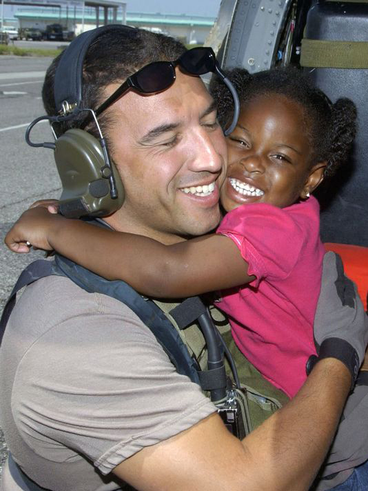 Then Staff Sgt. Mike Maroney hugging three-year-old Lashay Brown after rescuing her in 2005. (Airman 1st Class Veronica Pierce—Air Force)