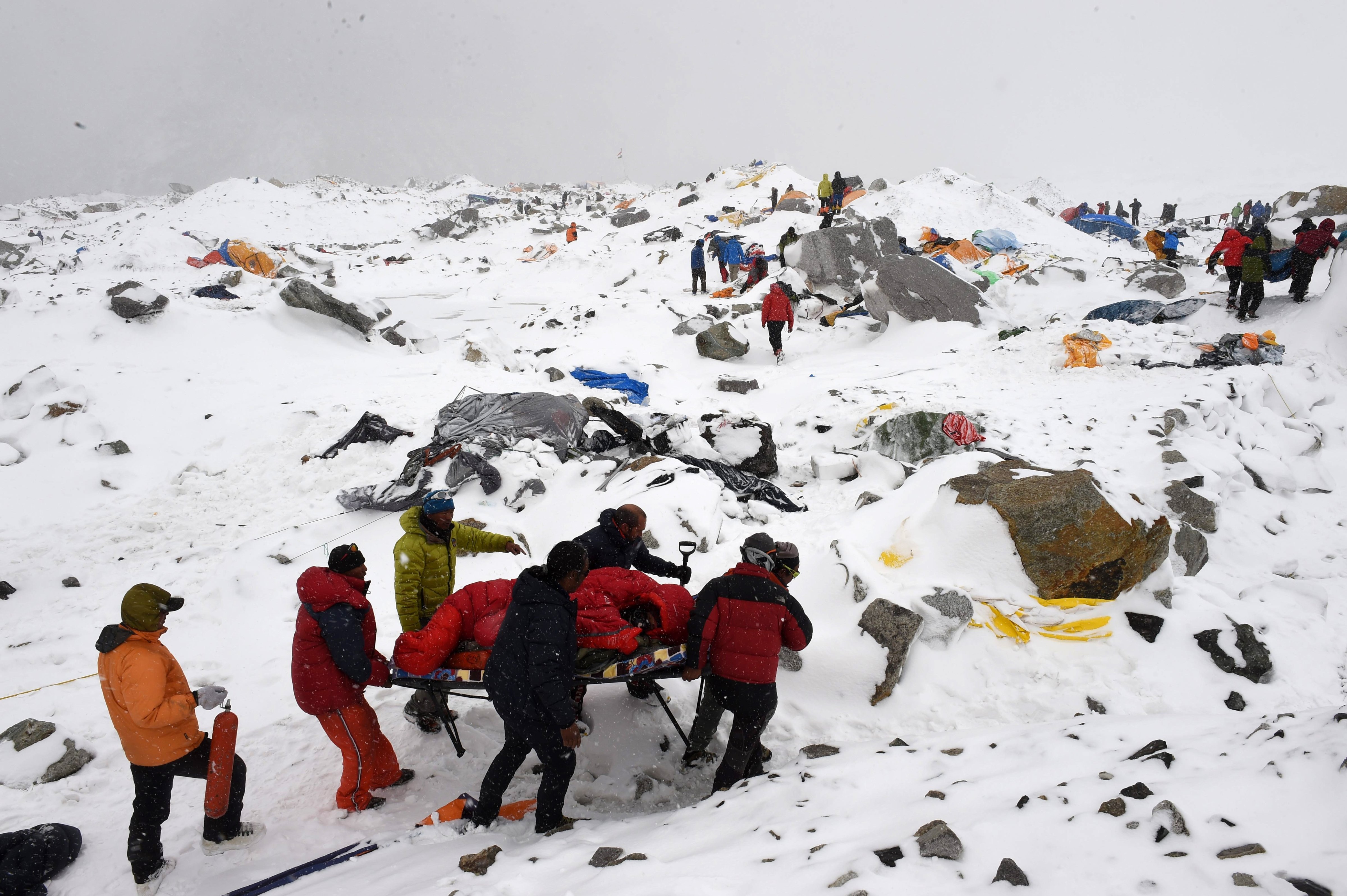 In this photograph taken on April 25, 2015, rescuers use a makeshift stretcher to carry an injured person after an avalanche triggered by an earthquake flattened parts of Everest Base Camp.   Rescuers in Nepal are searching frantically for survivors of a huge quake on April 25, that killed nearly 2,000, digging through rubble in the devastated capital Kathmandu and airlifting victims of an avalanche at Everest base camp. (Roberto Schmidt&mdash;AFP/Getty Images)