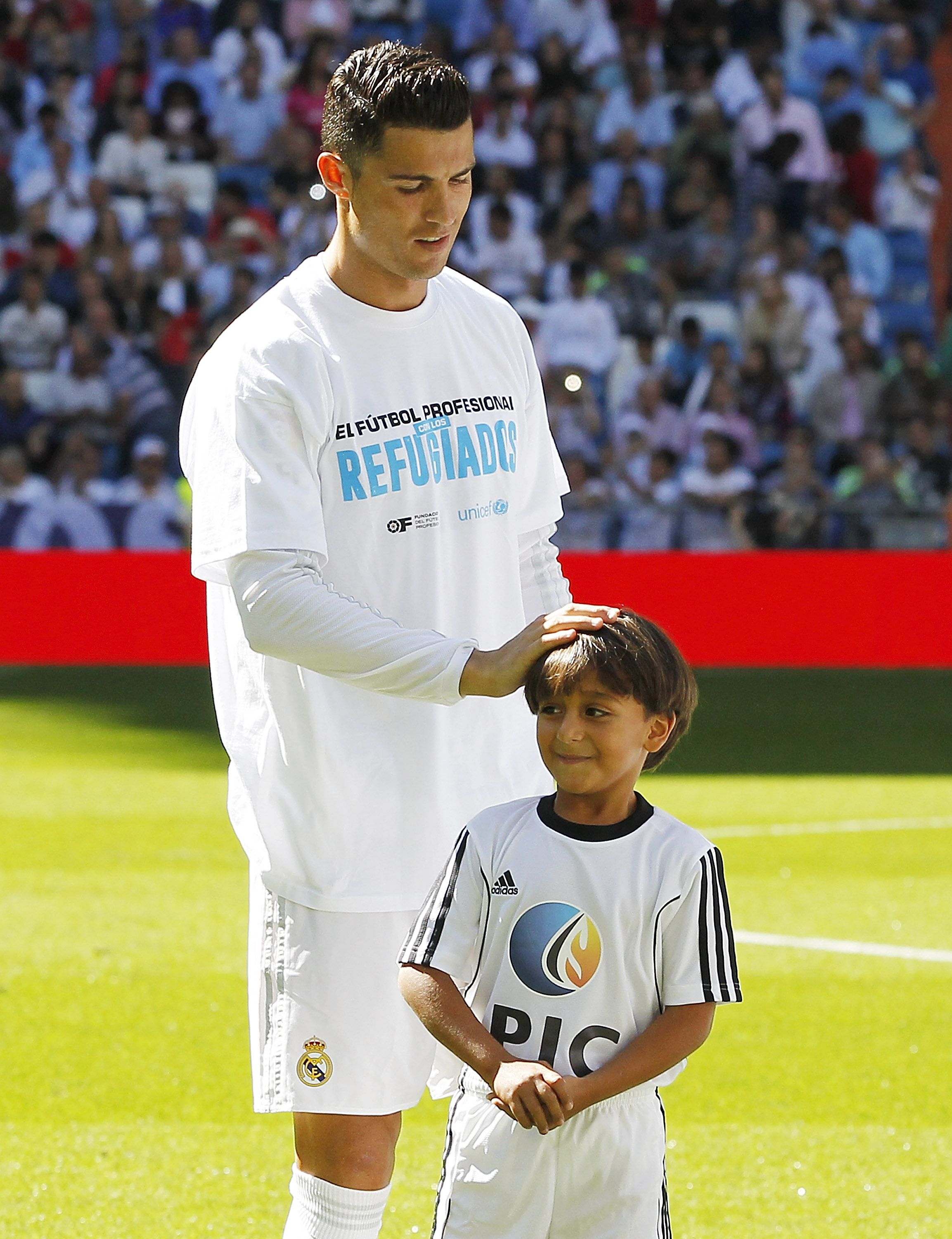Zaid, son of Osama Abdul Mohsen, the Syrian refugee who was tripped over by a Hungarian journalist, pose with Cristiano Ronaldo of Real Madrid before the La Liga match between Real Madrid CF and Granada CF at Estadio Santiago Bernabeu on Sept. 19, 2015 in Madrid, Spain. (Angel Martinez—Real Madrid/Getty Images)