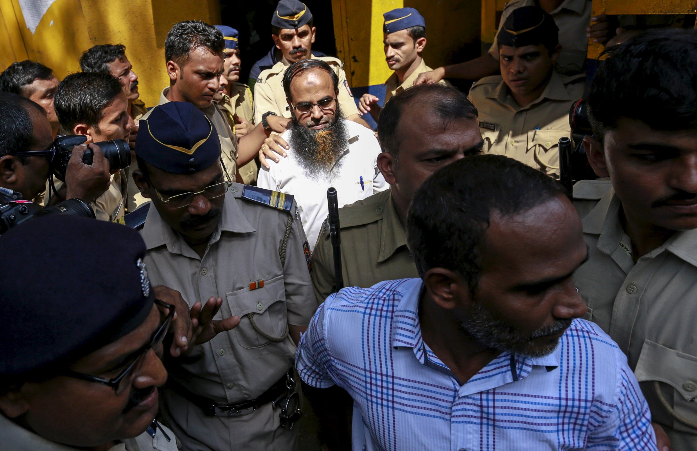 Two of the 12 men, convicted of planning several blasts on crowded commuter trains in the financial capital of Mumbai in 2006, is escorted by police to a court in Mumbai