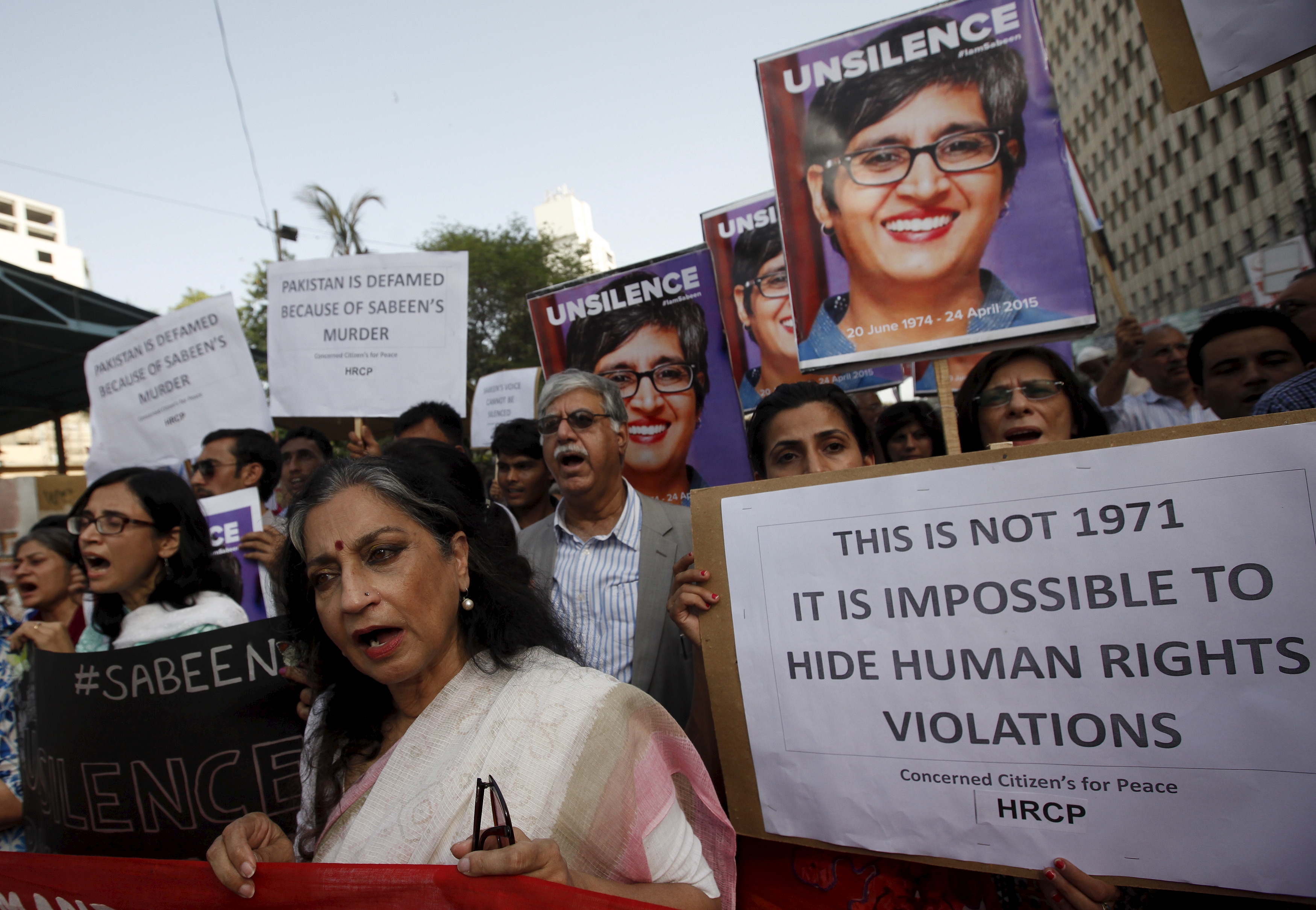 People chant slogans as they hold signs and pictures of Sabeen Mahmud, a human rights activist who was shot by gunmen, during a protest demanding justice outside the Press Club in  Karachi, Pakistan, April 30, 2015. (Akhtar Soomro—Reuters)