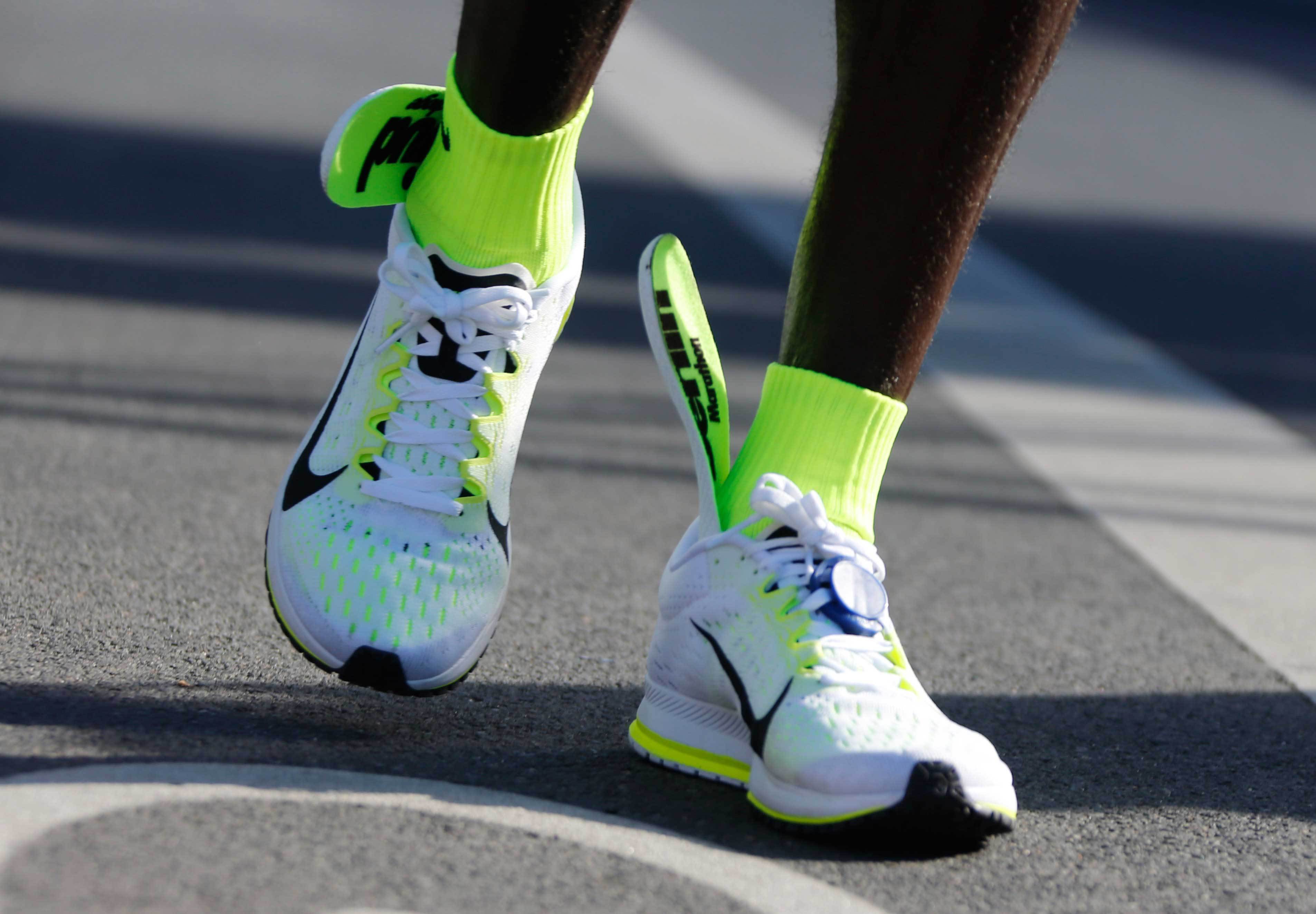 The insoles of Kenya's Kipchoge's running shoes are seen slipping up to his ankles after he crosses finish line to win the men's 42nd Berlin marathon