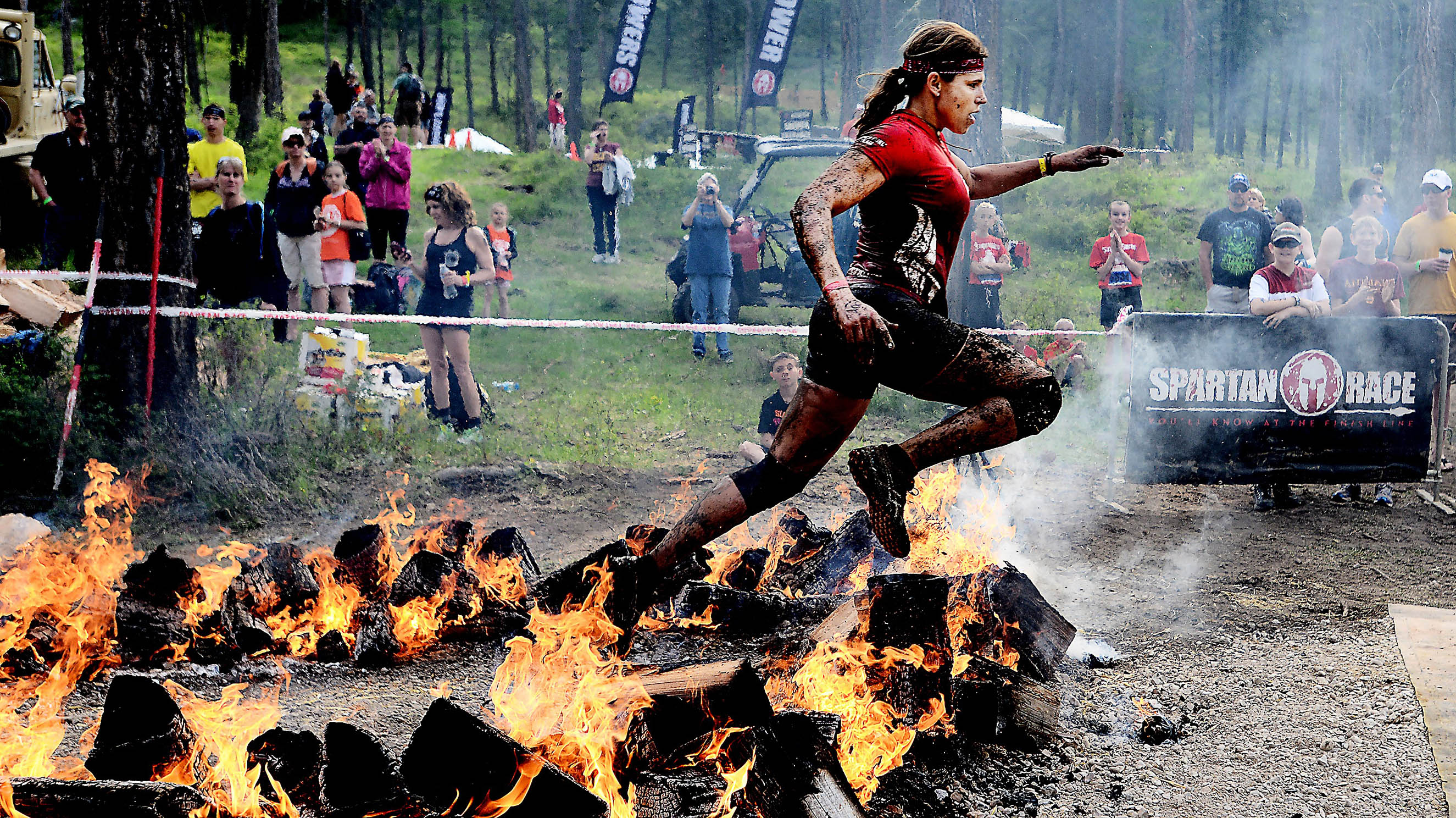 A competitor leaps across a ring of fire during a Spartan Race in Montana. The events are now in 20 countries, and the championship will air on NBC (Brenda Ahearn/Daily Inter Lake)