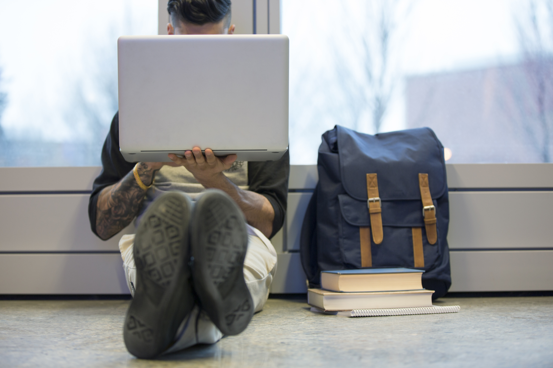 student-sitting-laptop-backpack