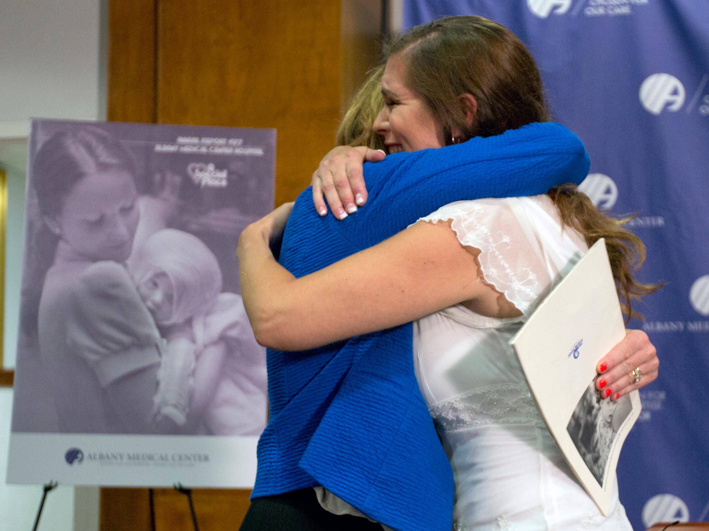 Nurse Susan Berger (L) and Amanda Scarpinati hug during a news conference at Albany Medical Center in Albany, N.Y. on Sept. 29, 2015.