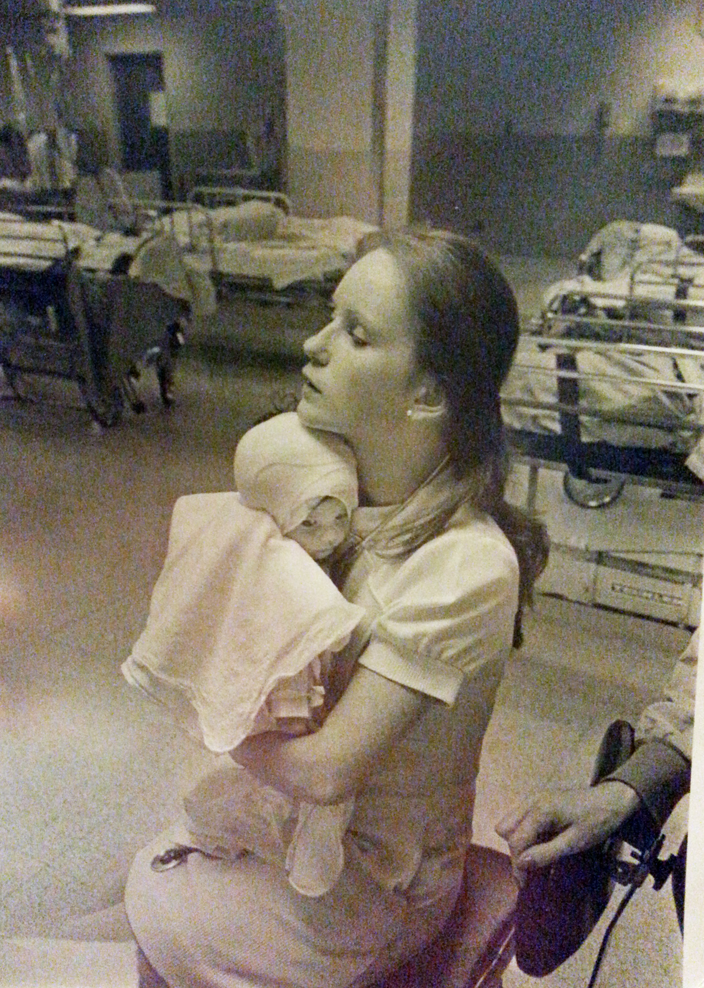 In this 1977 photo provided by Albany Medical Center, nurse Susan Berger cuddles infant Amanda Scarpinati, who had been severely burned by a steam vaporizer at home, in the pediatric unit at Albany Medical Center in Albany, N.Y.