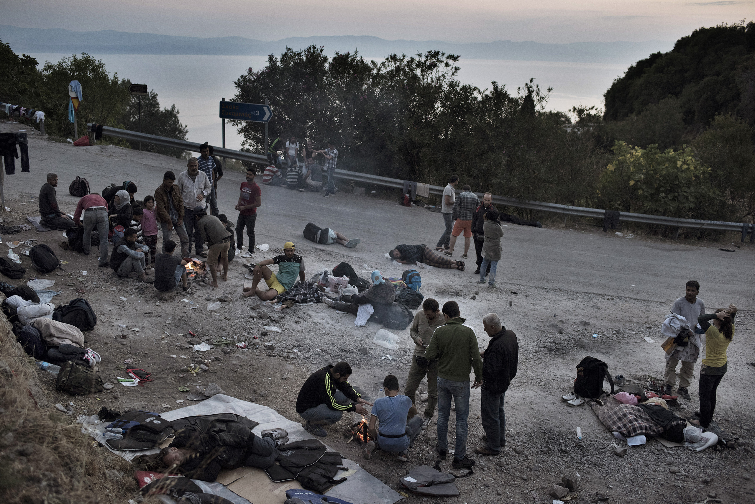 Migrants rest in makeshift camps on the roadside as they make their way on foot across the Greek island of Lesbos, the first piece of European land they reached after crossing in rickety boats from neighboring Turkey.
