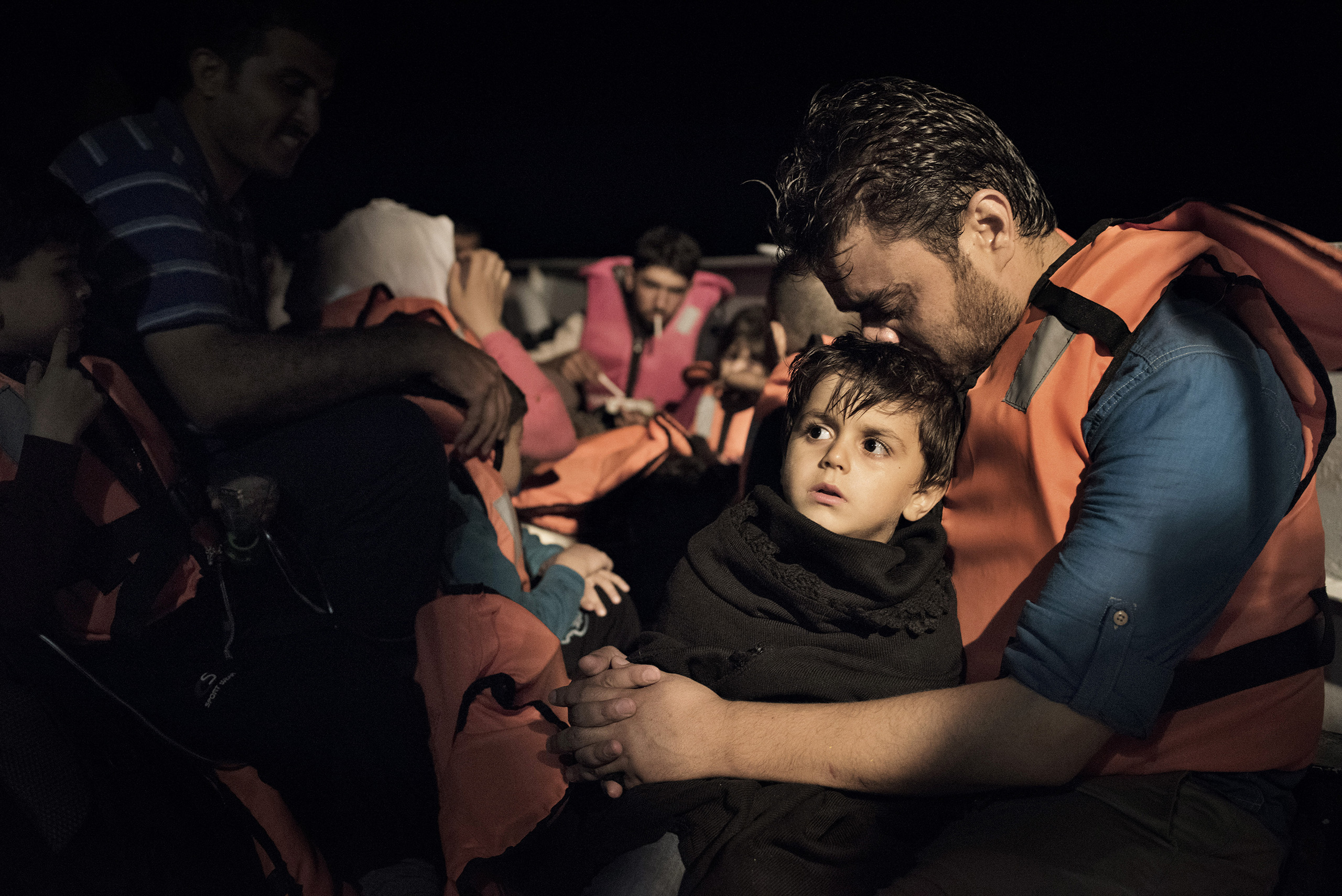 A Syrian migrant comforts his child aboard a Greek coast guard vessel that has just rescued them from an overcrowded motorboat in the waters near the Greek-Turkish border. Sept. 6, 2015.