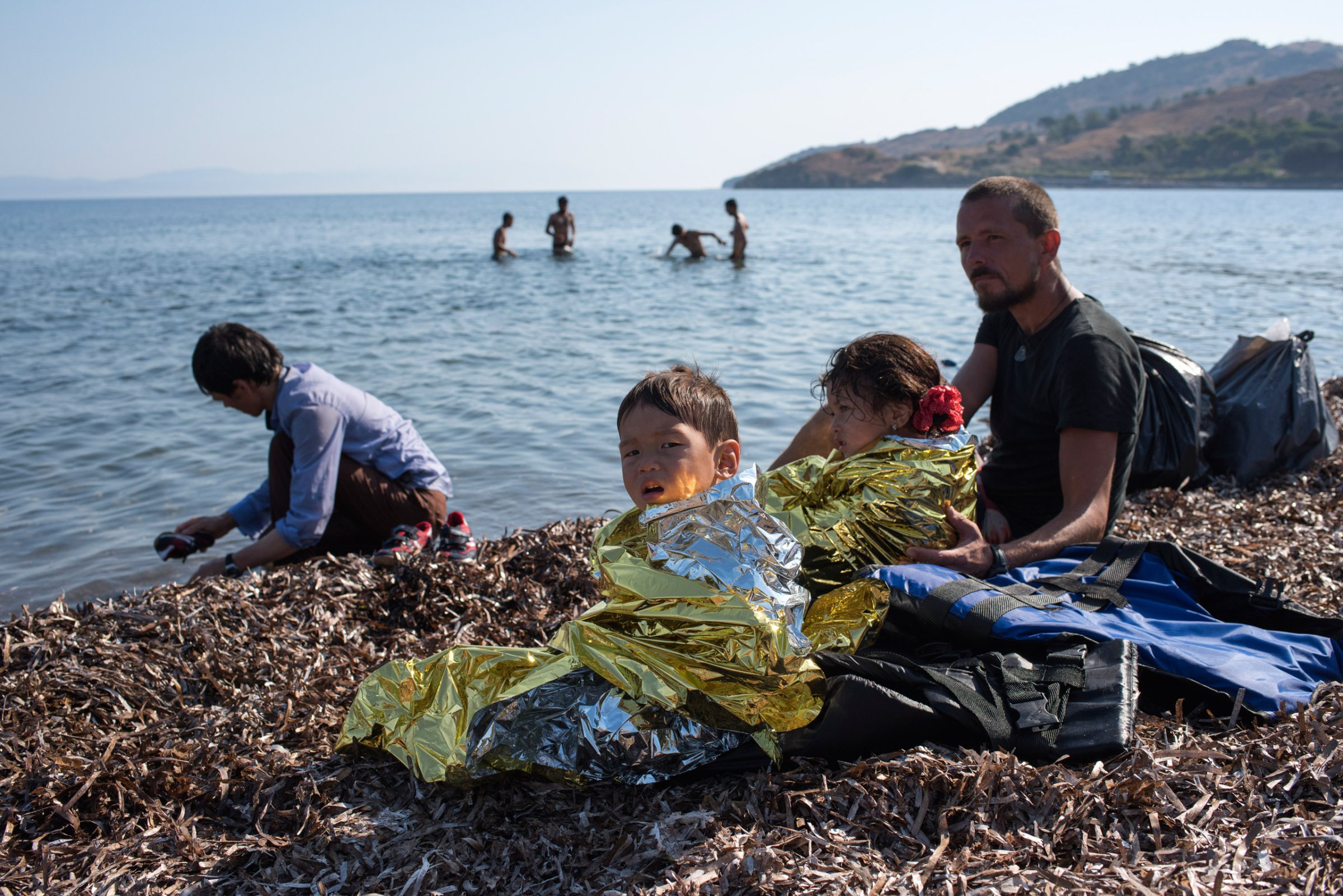 LESVOS, Greece - Sept. 4, 2015 A German volunteer helps an Afghan family that has just come by boat from Turkey to the Greek island of Lesvos, where they touch European soil for the first time since fleeing conflict and poverty in their homeland.