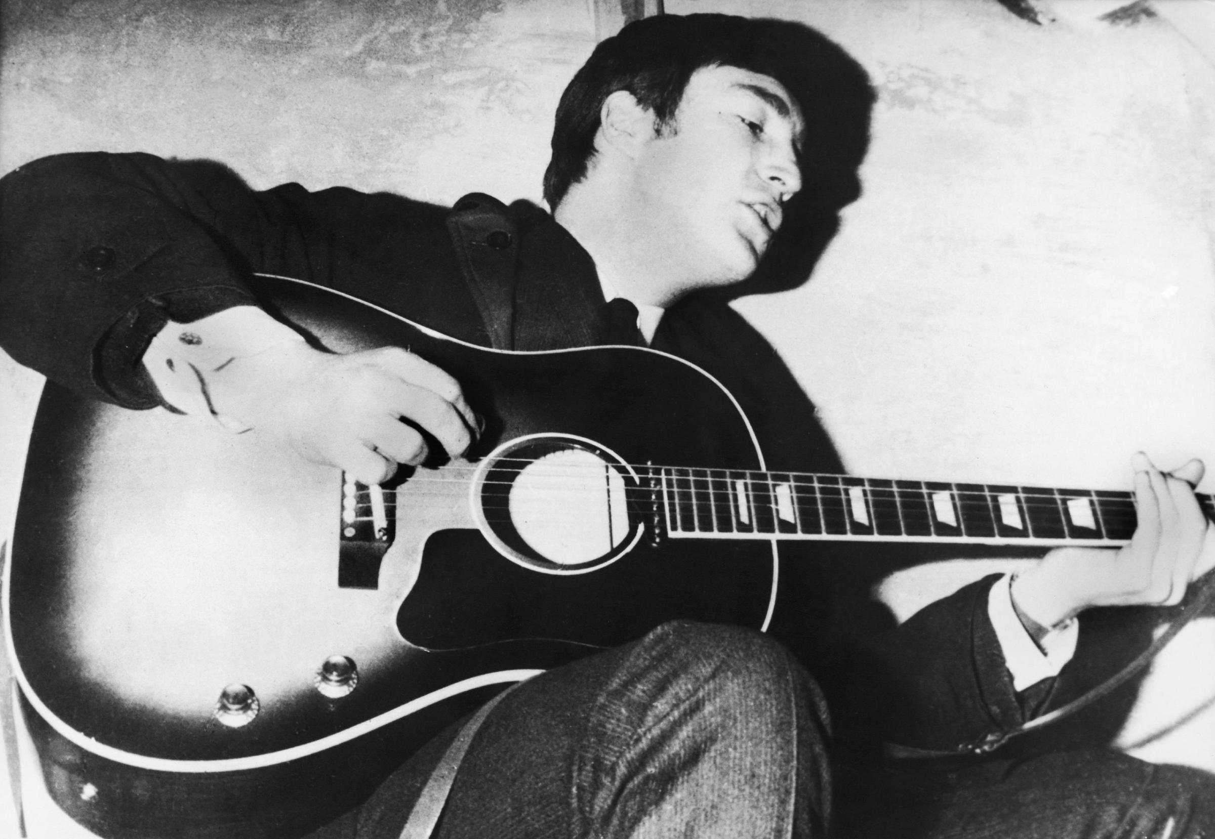 John Lennon playing guitar, circa 1960.