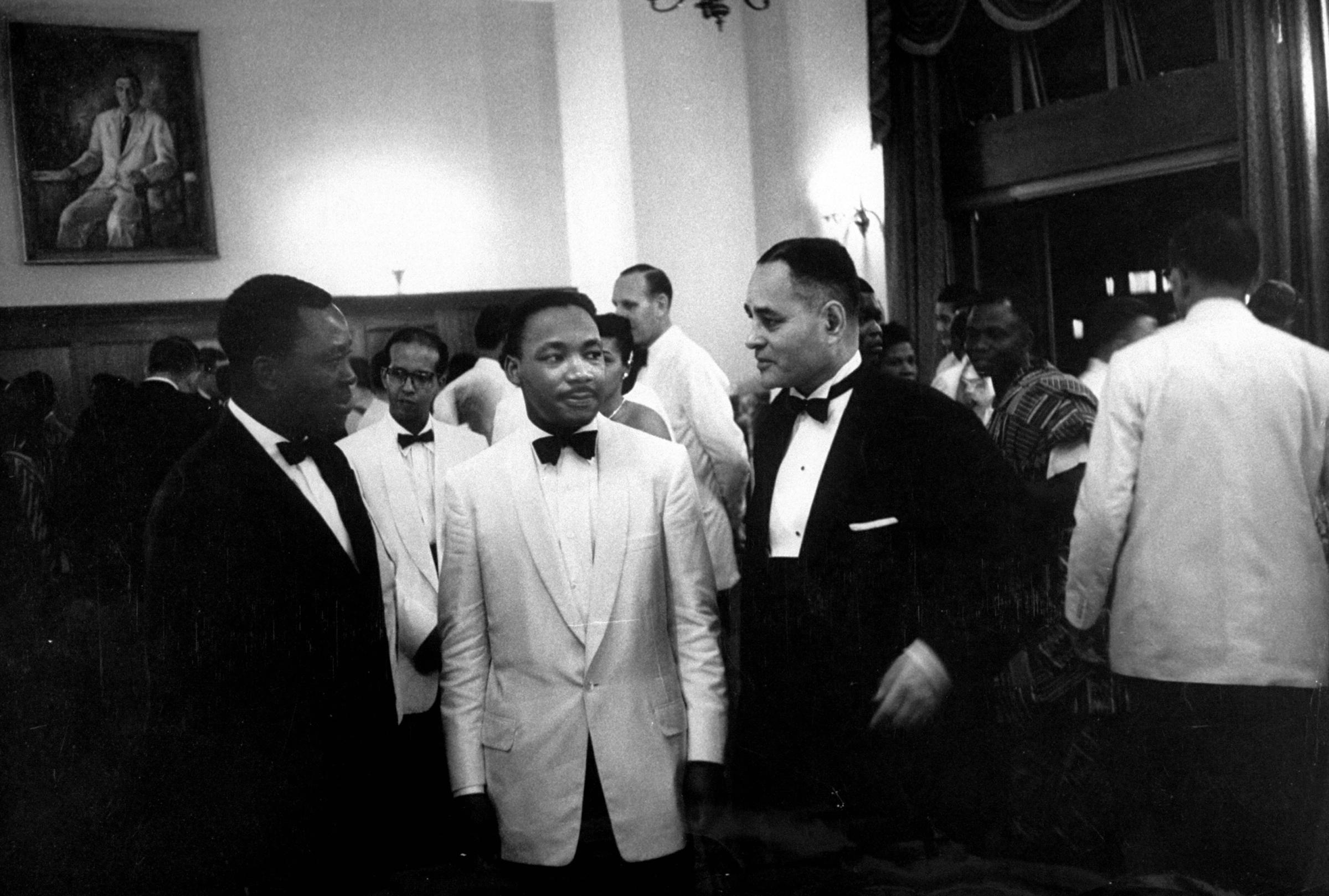 Dr. Ralph J. Bunche (R) standing with civil rights leader Rev. Martin Luther King Jr. (C) at the Ghana independence ceremonies, 1957.