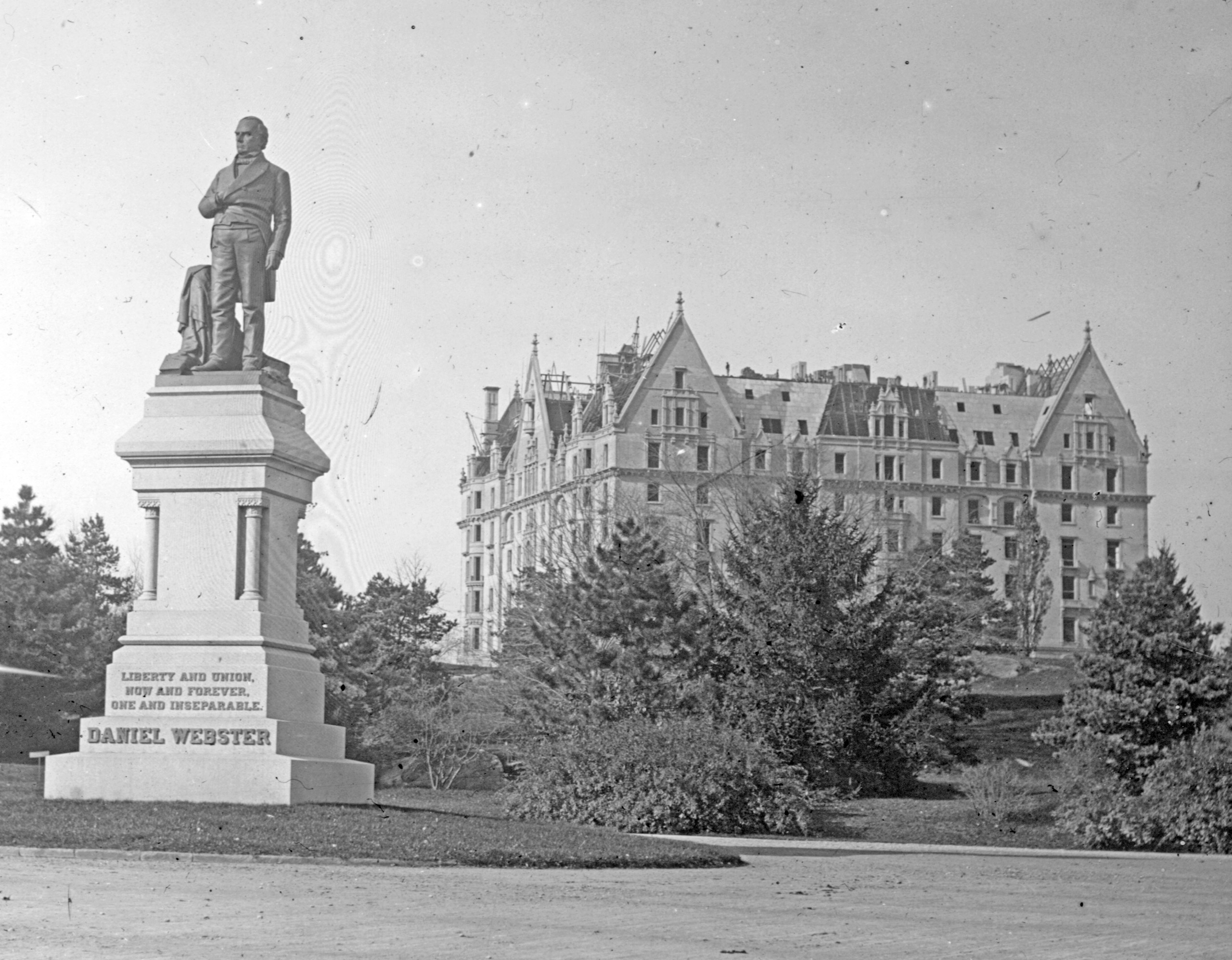 Perhaps the earliest known image of the Dakota, while still under construction. The Central Park statue of Daniel Webster, in bronze on a granite pedestal, was sculpted by Thomas Ball and erected in 1876, only four years before work on the Dakota was begun.