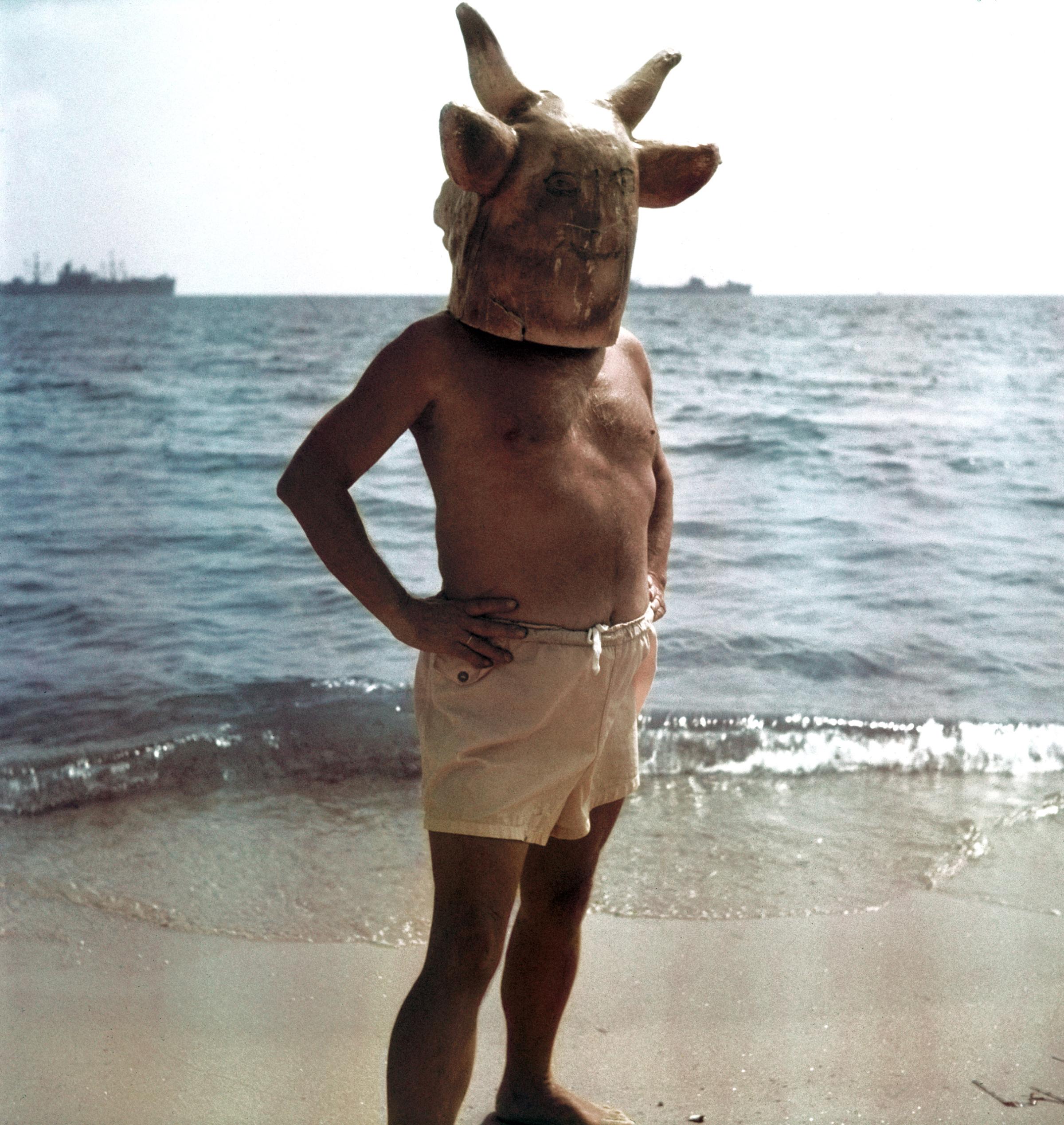 Pablo Picasso wearing a minotaur head mask on the beach at Golfe Juan near Vallauris.
