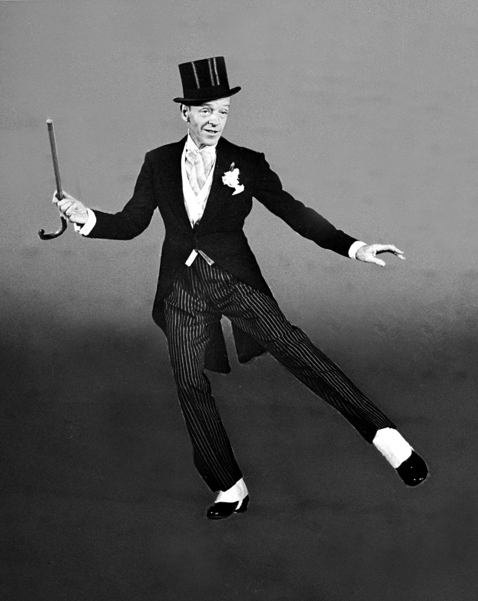Dancer Fred Astaire clad in top hat, tails and spats, twirling cane in one hand as he dances "Puttin' on the Ritz" number for the movie "Blue Skies.".