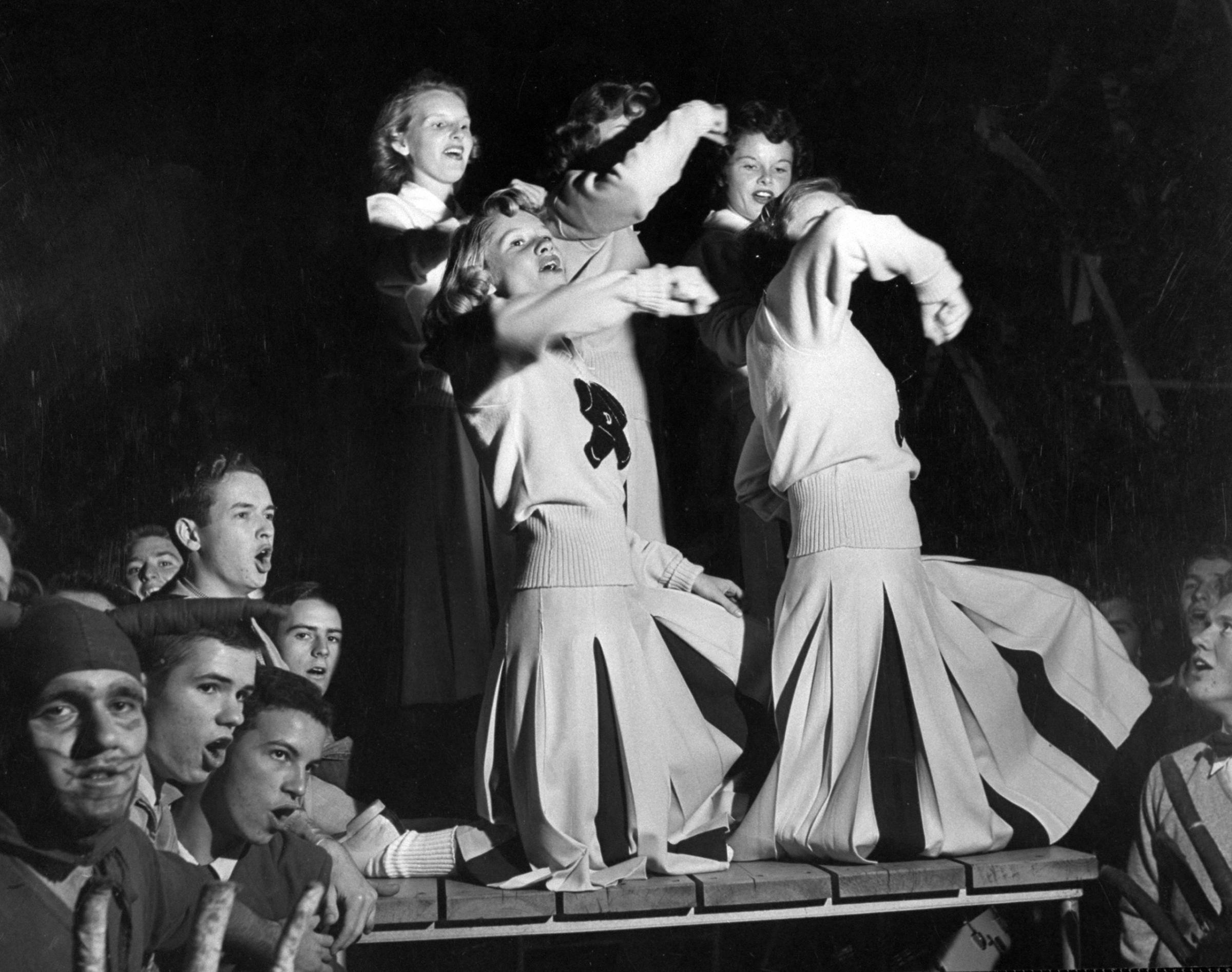 Duke cheerleaders cheering among the fans in the bleachers, 1952.