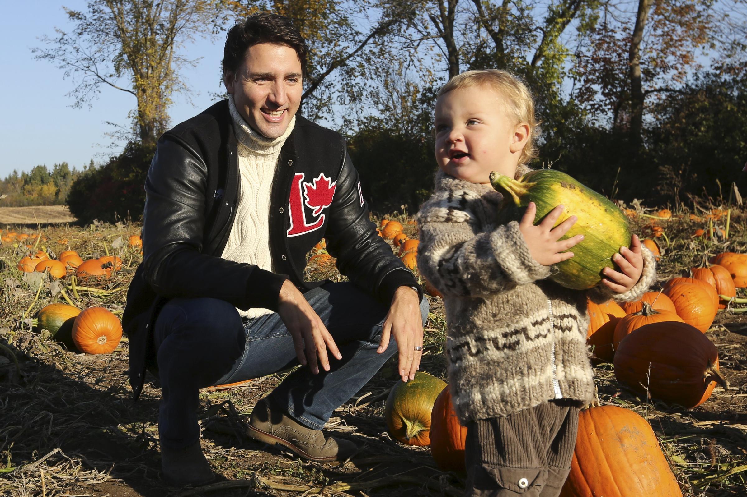 Liberal leader Trudeau watches as his son Hadrien carries a pumpkin while touring a pumpkin patch in Gatineau