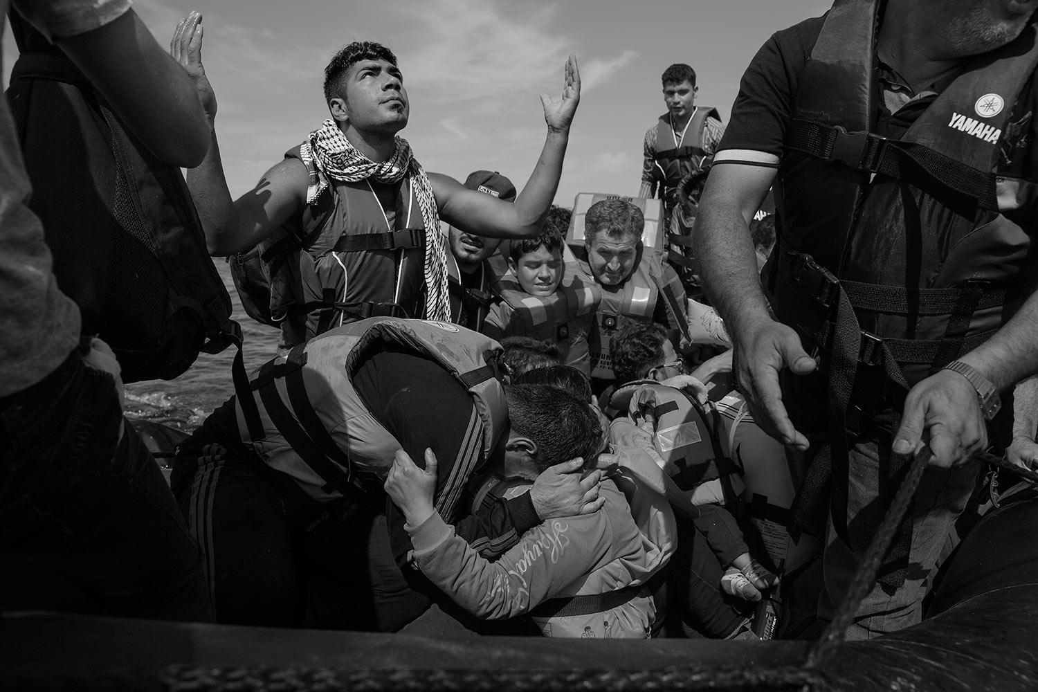 Refugees celebrate after arriving on the beach in Lesbos, Greece. Thousands of migrants each day set out from nearby Turkey for the Greek island, riding in barely seaworthy rubber boats. Some don’t make it, Sept. 26, 2015.