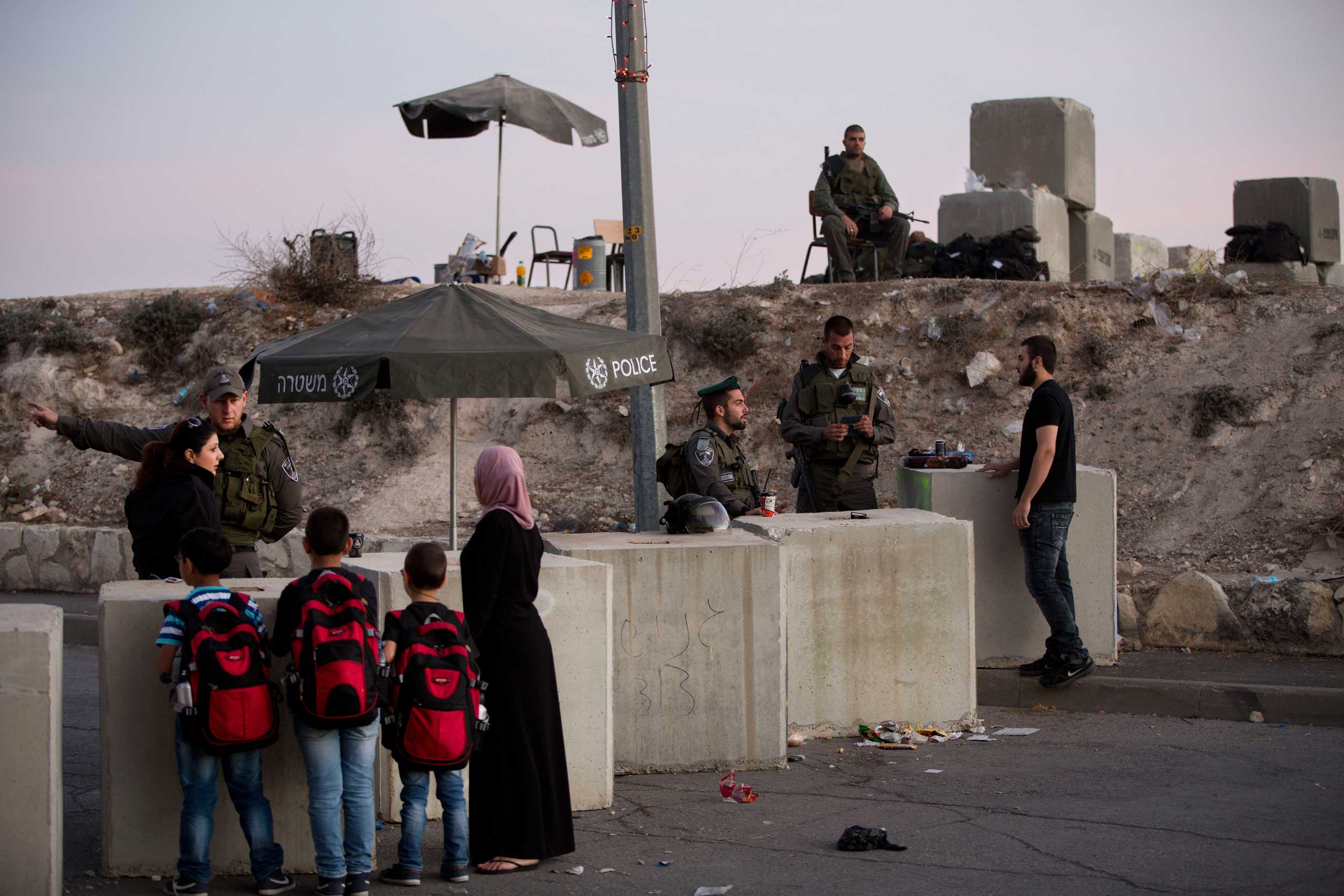 Israeli border police check Palestinian's identification cards at a checkpoint as they exit the Arab neighborhood of Issawiyeh in Jerusalem, on Oct. 22, 2015. (Oded Balilty—AP)