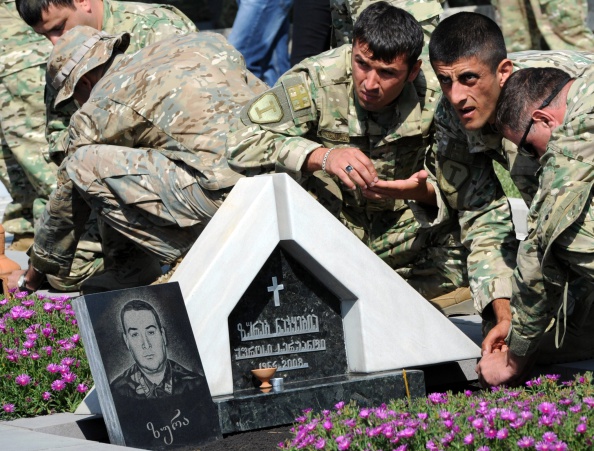 Georgian soldiers lay flowers at a grave in a memorial cemetery in Tbilisi on August 8, 2014, as Georgians mark the sixth anniversary of the Ossetian conflict (Vano Shlamov—AFP/Getty Images)