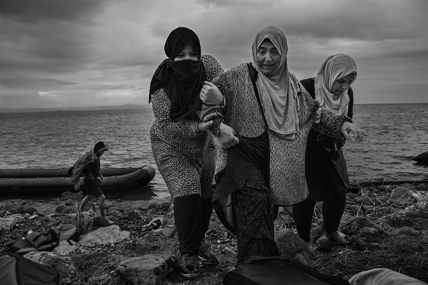 Two women help a third scramble ashore after arriving on the beach in Lesbos, Greece, September 23, 2015. James Nachtwey for TIME