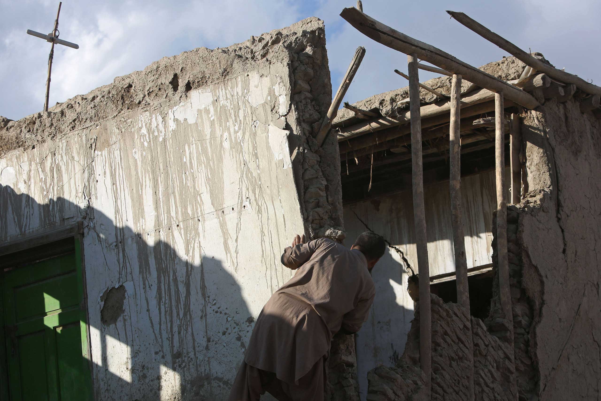 An Afghan man looks at a damaged house following a powerful earthquake today that could be felt across South Asia, in Kabul, on Oct. 26, 2015.
