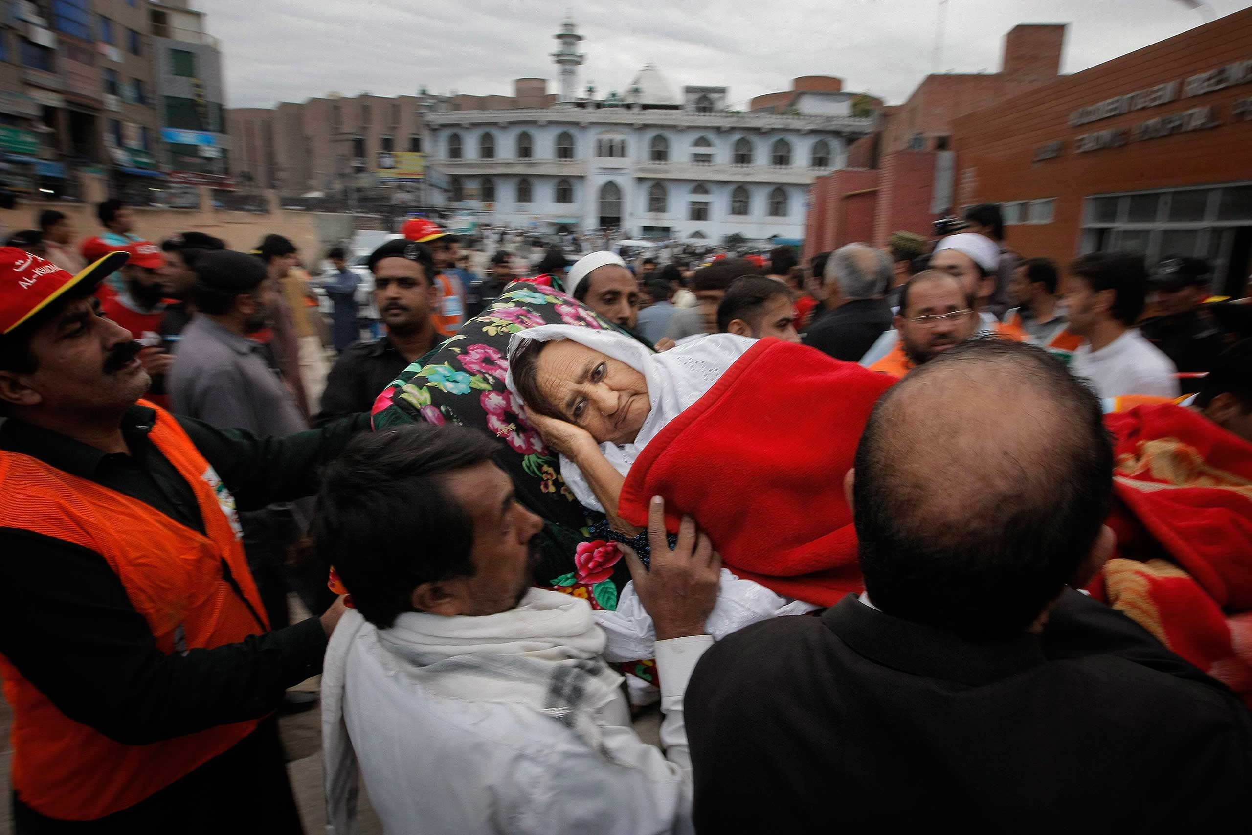 People rush an injured woman to a local hospital in Peshawar, Pakistan, on Oct. 26, 2015.