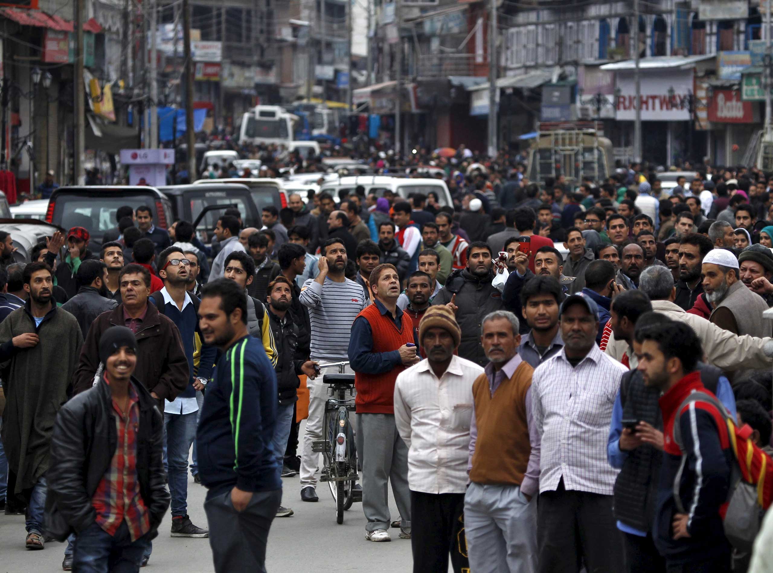 People stand on a road after vacating buildings following an earthquake in Srinagar, India, on Oct. 26, 2015.