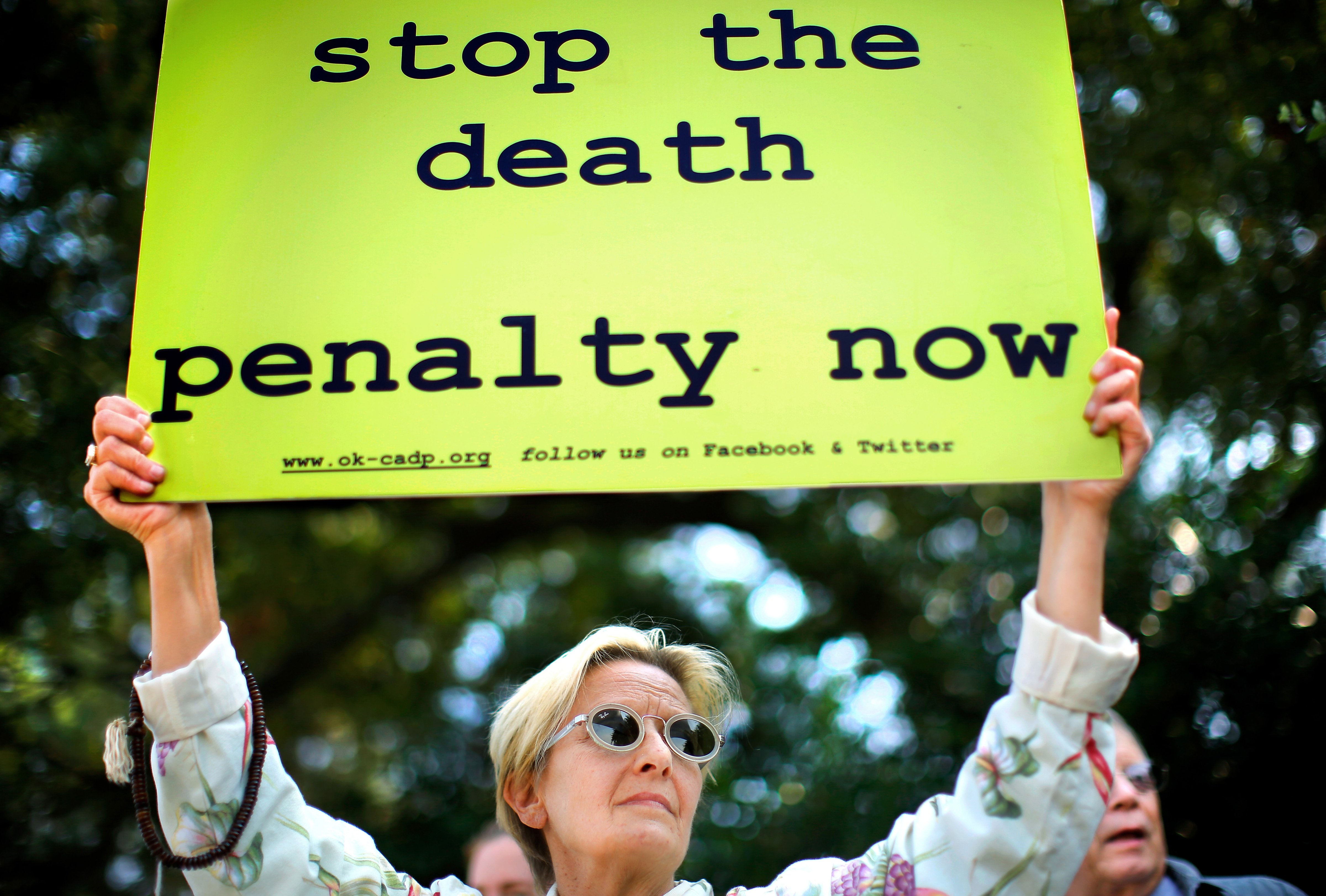 Karin Stafford joins a crowd of protesters in front of the governor's mansion in Oklahoma City, Okla., Sept. 30, 2015. (Jim Beckel—AP)